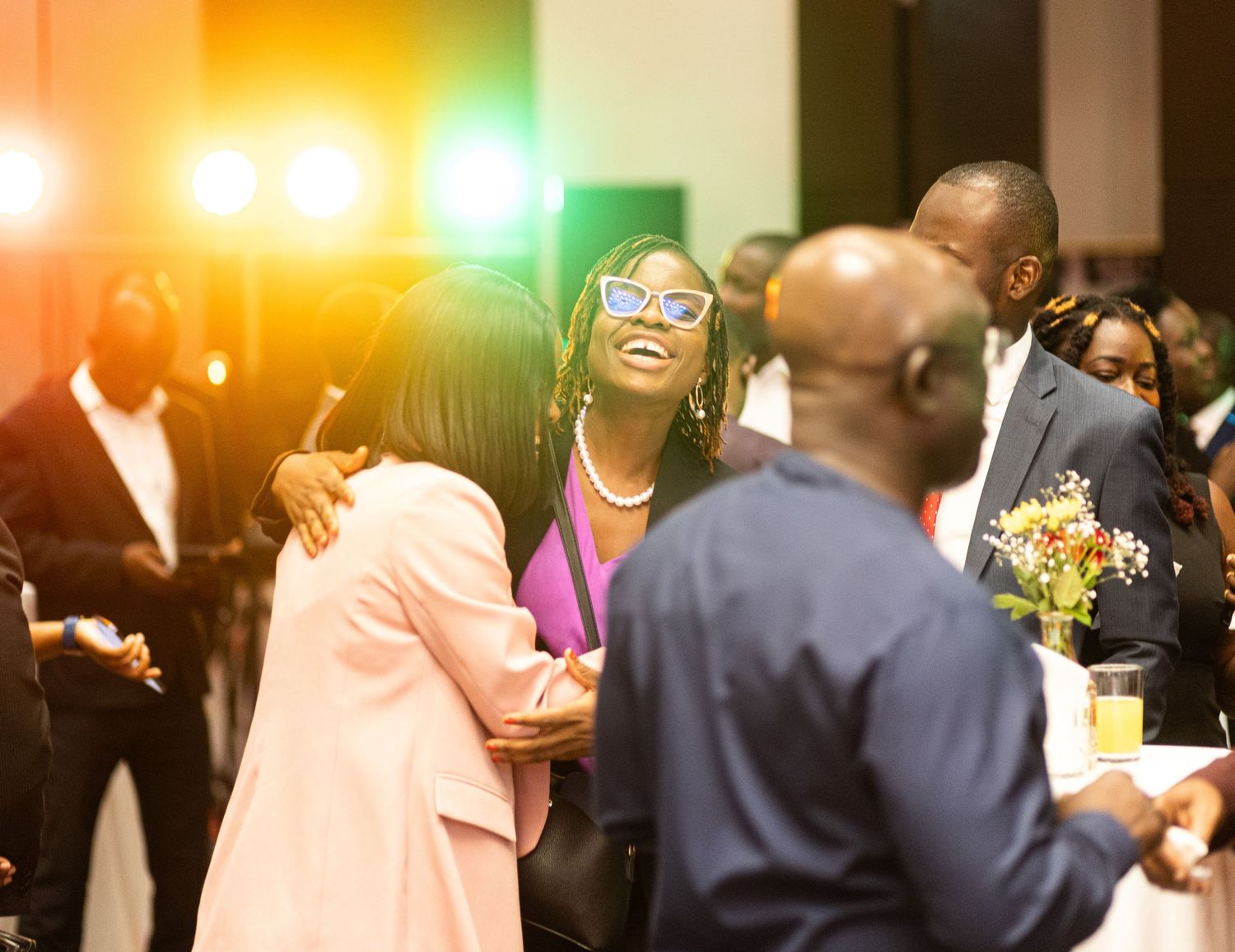 A lively group of people enjoying themselves at a social gathering with warm lighting and festive atmosphere.
