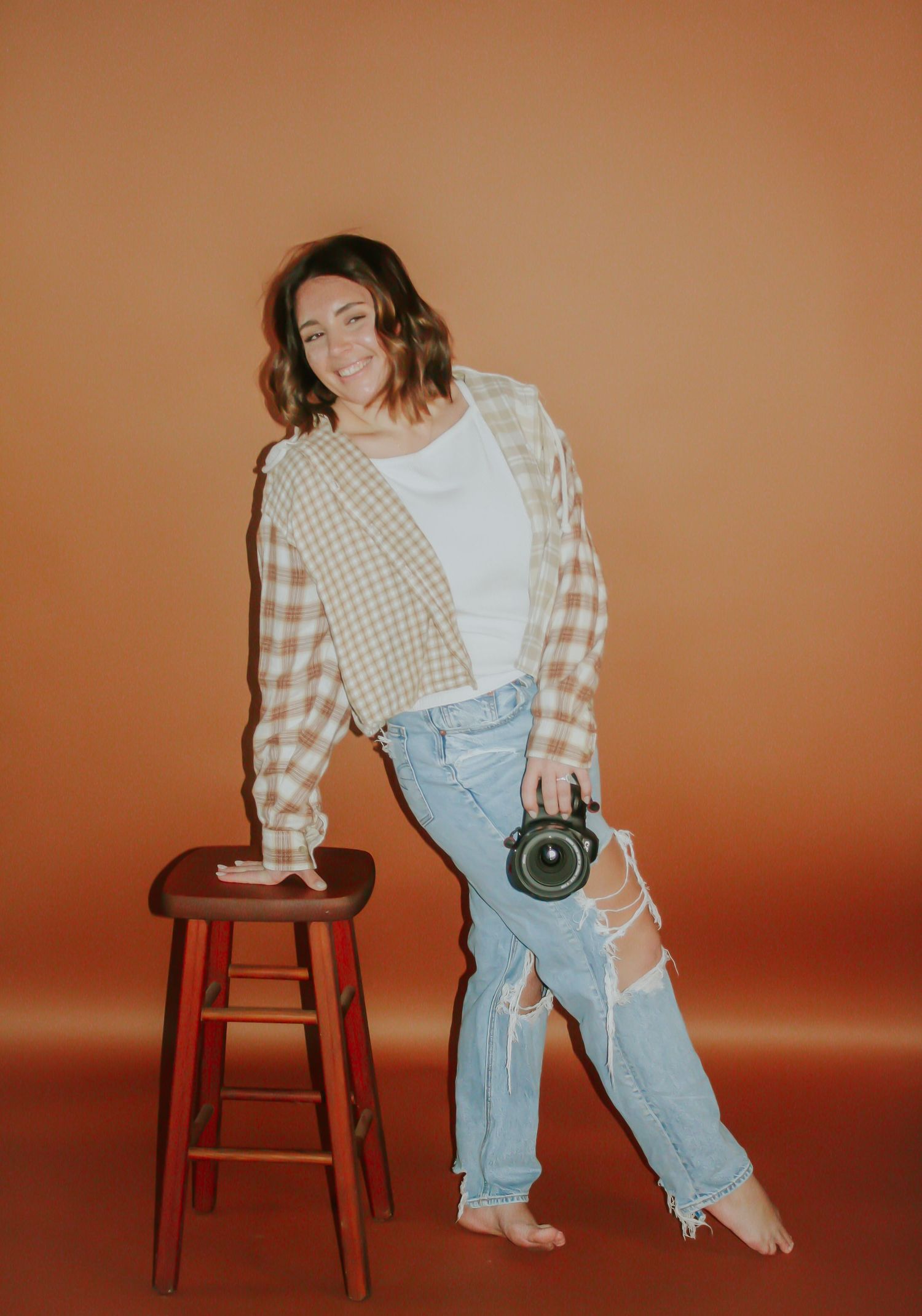Fashion portraits featuring checkered shirt and light denim in warm studio lighting.