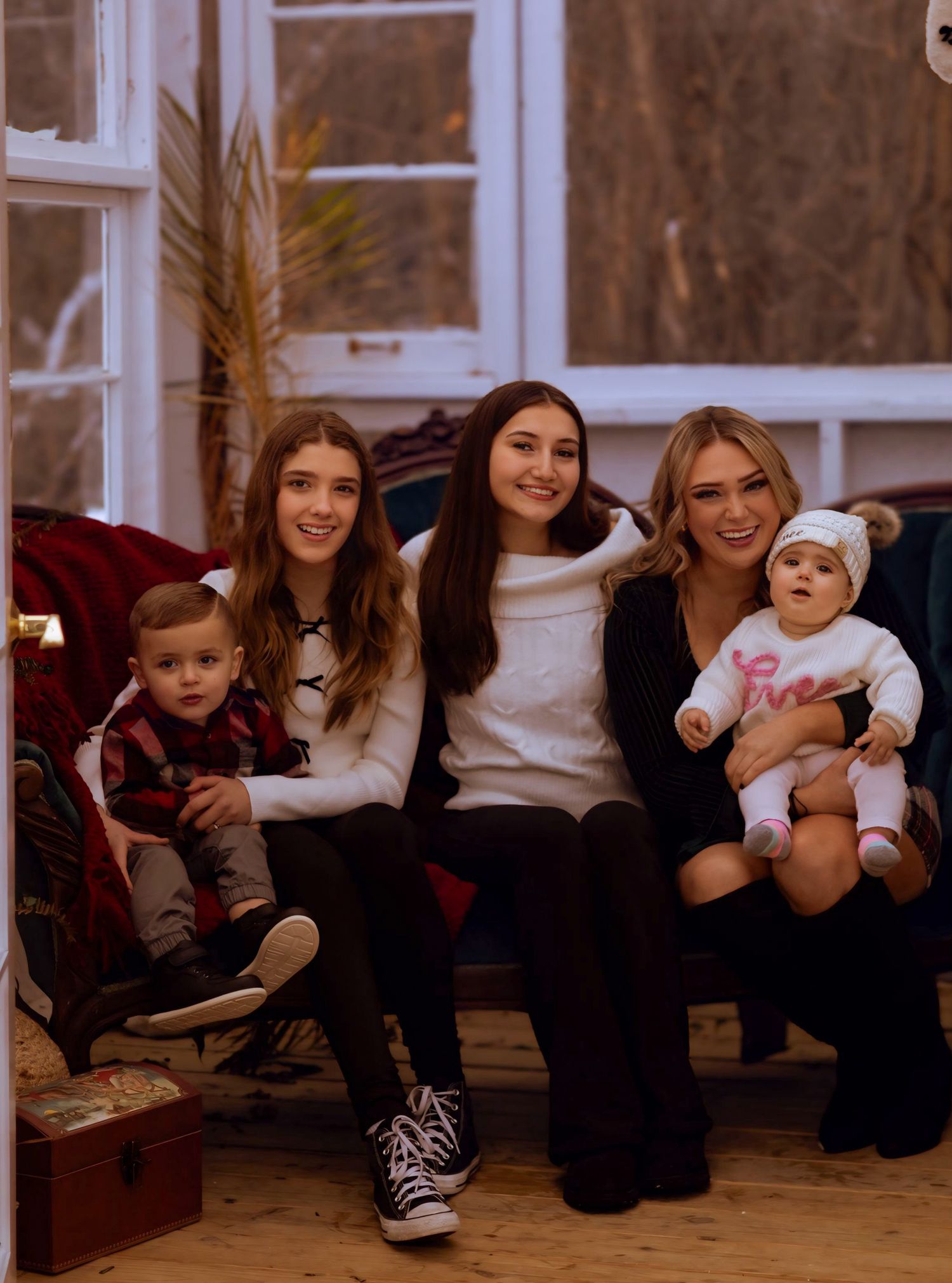 A group of people sitting together on a couch in a cozy living room setting.