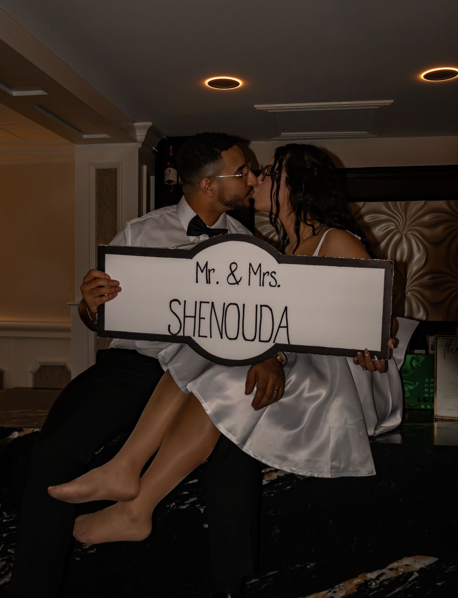Wedding reception signage displayed in a dimly lit venue with decorative lighting.