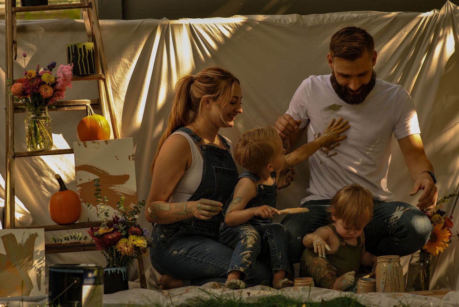 A family sits together on a couch playing with wooden blocks and toys in a warmly lit living room.