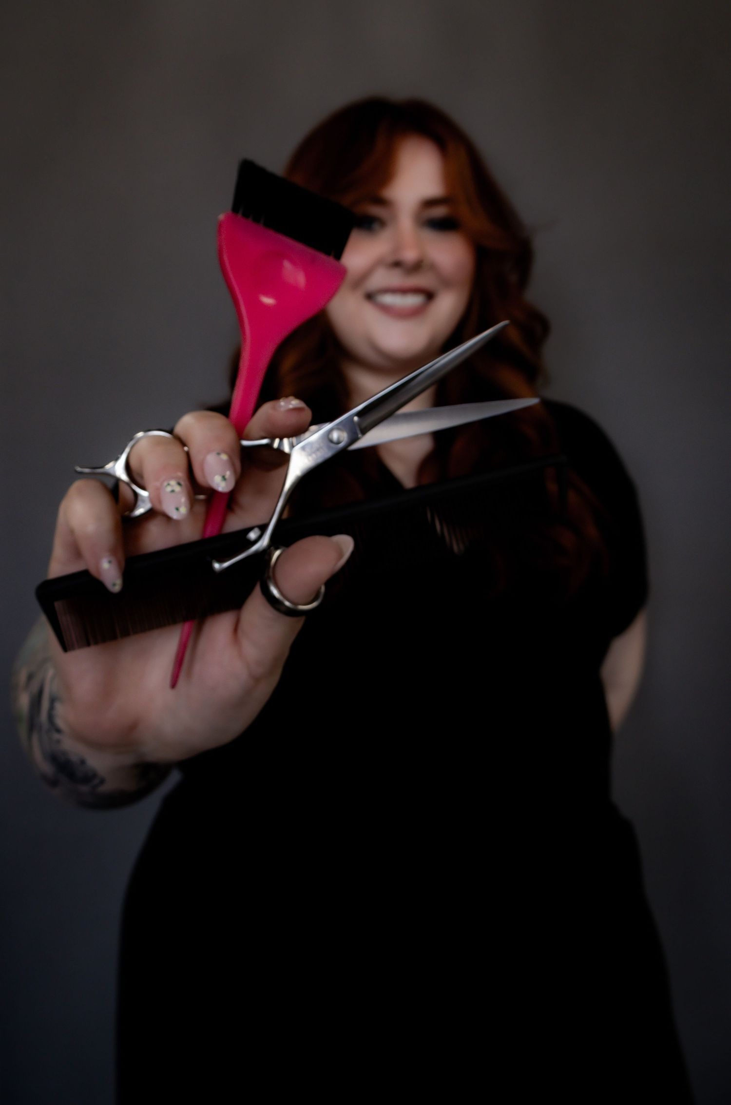 Artistic series showing pink and silver hairdressing scissors being displayed against dark background.