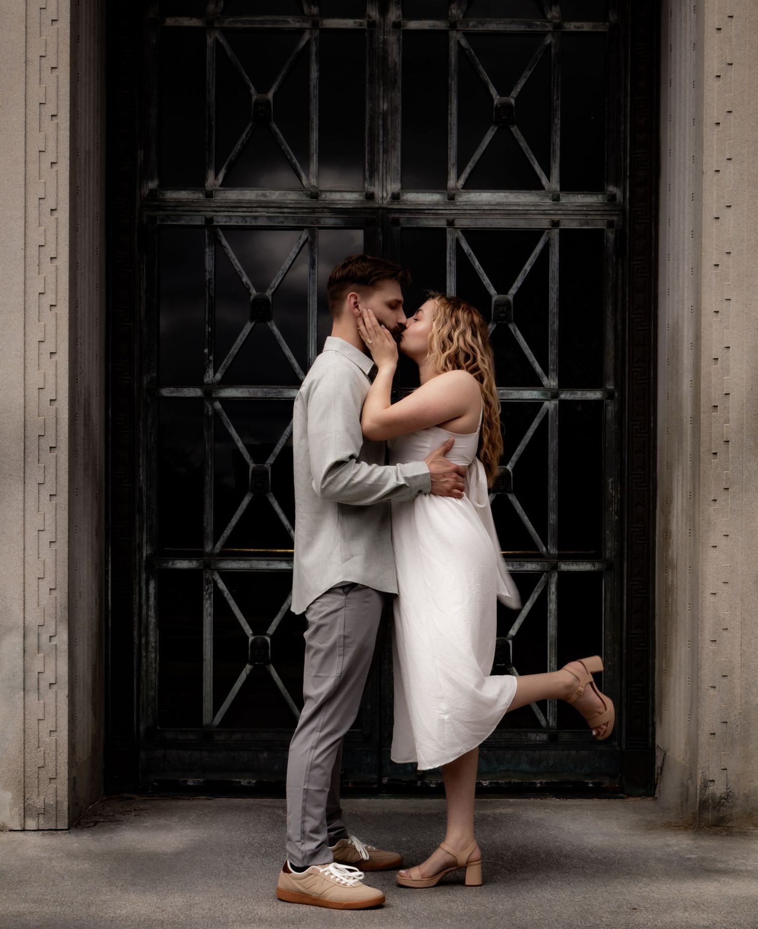An intimate wedding moment captured against an industrial architectural backdrop.