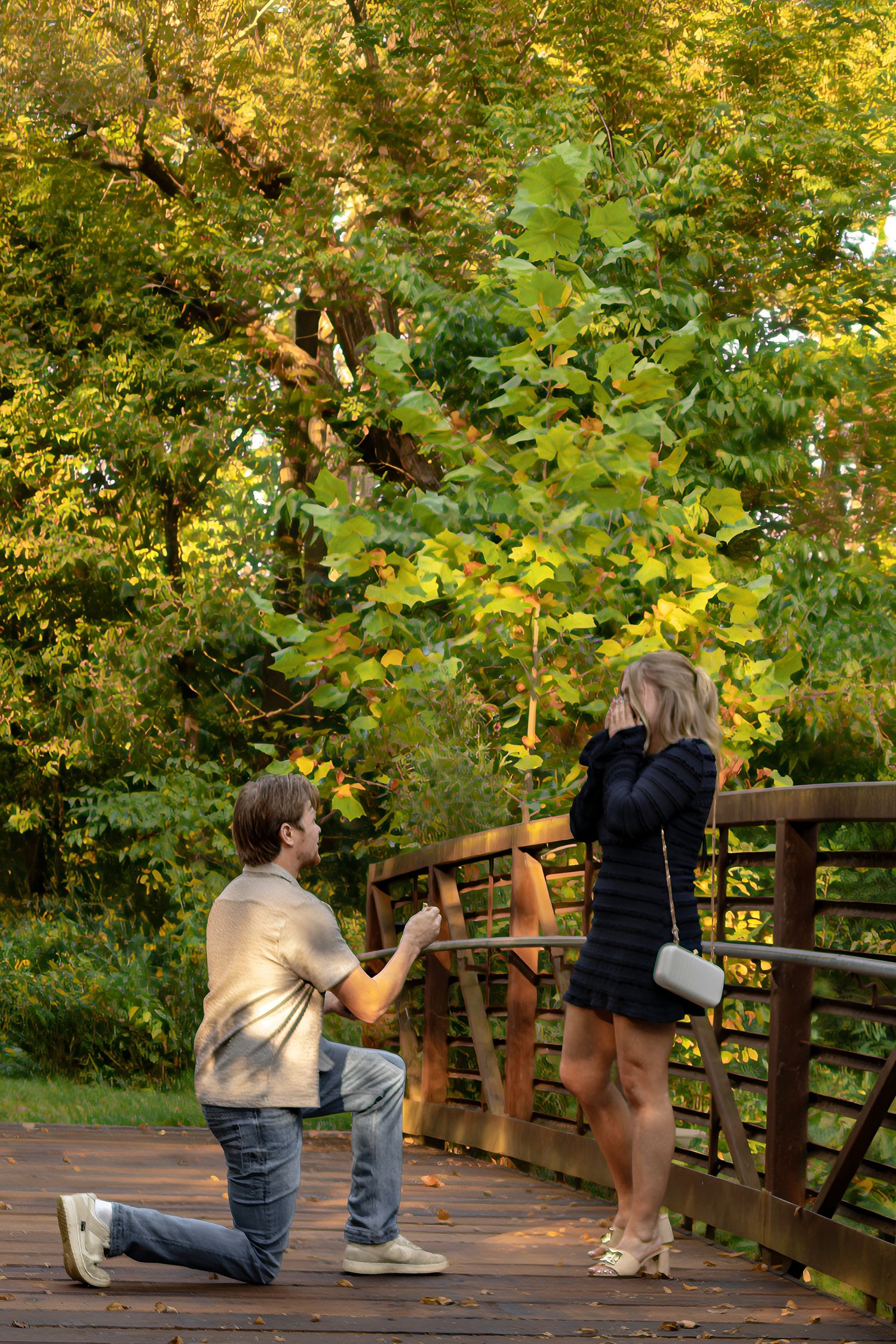 Sequence of a surprise proposal moment on a wooden bridge in a park setting.