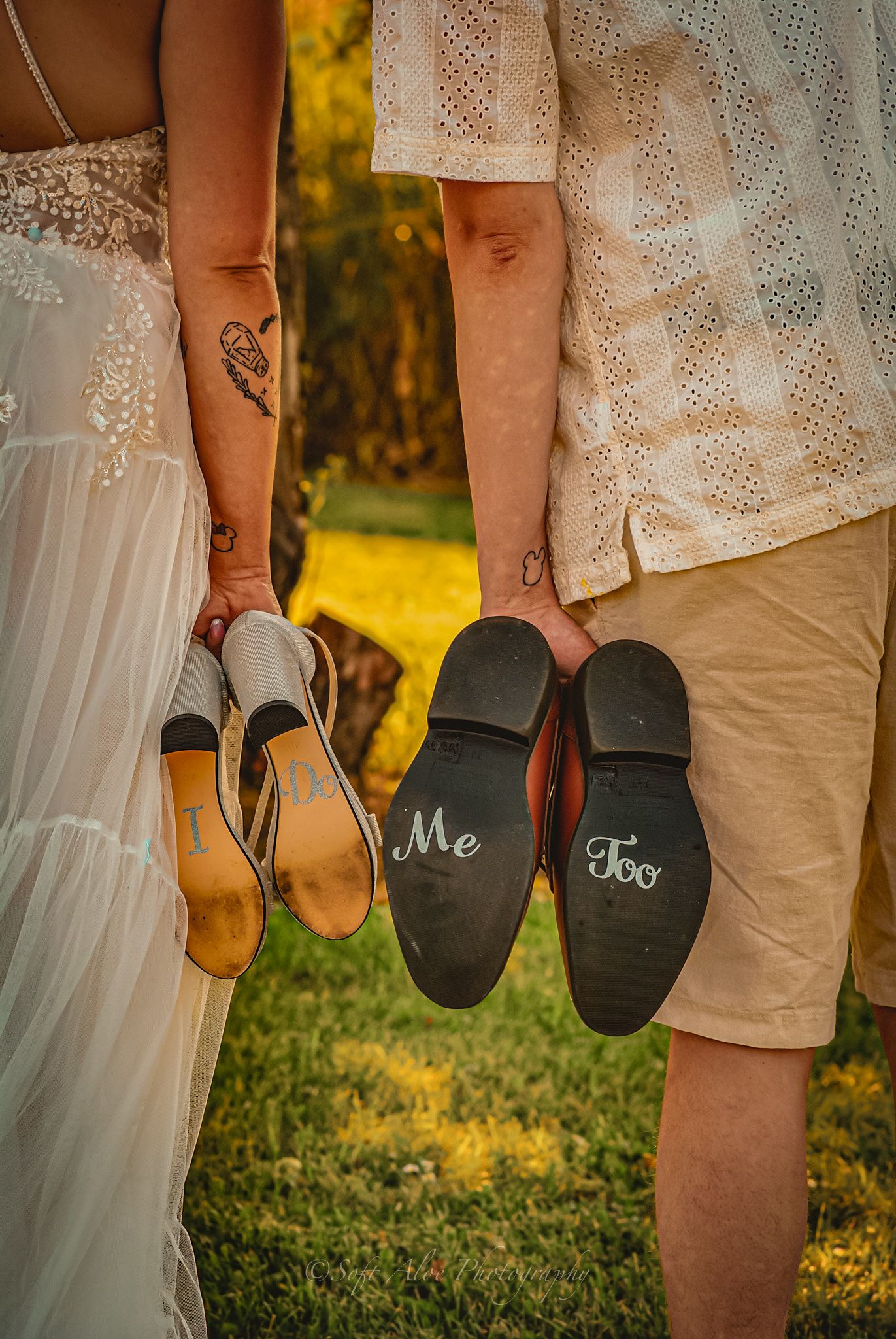 Couple's feet wearing flip flops with 'Mr' and 'Mrs' text written on them during an outdoor wedding photoshoot.