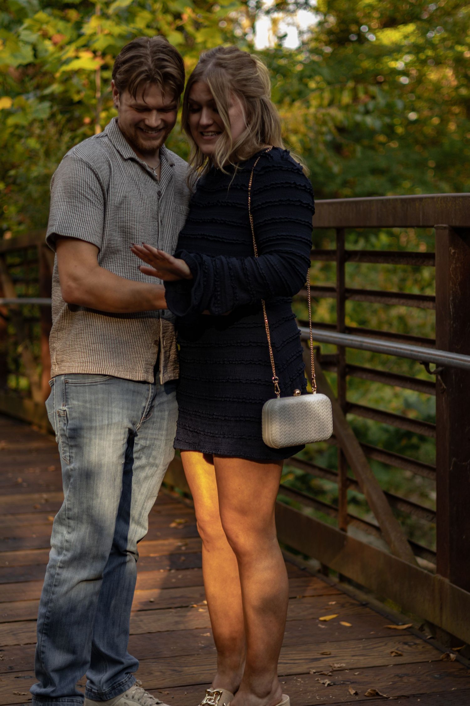 Couple sharing intimate moments on a wooden deck surrounded by autumn foliage.