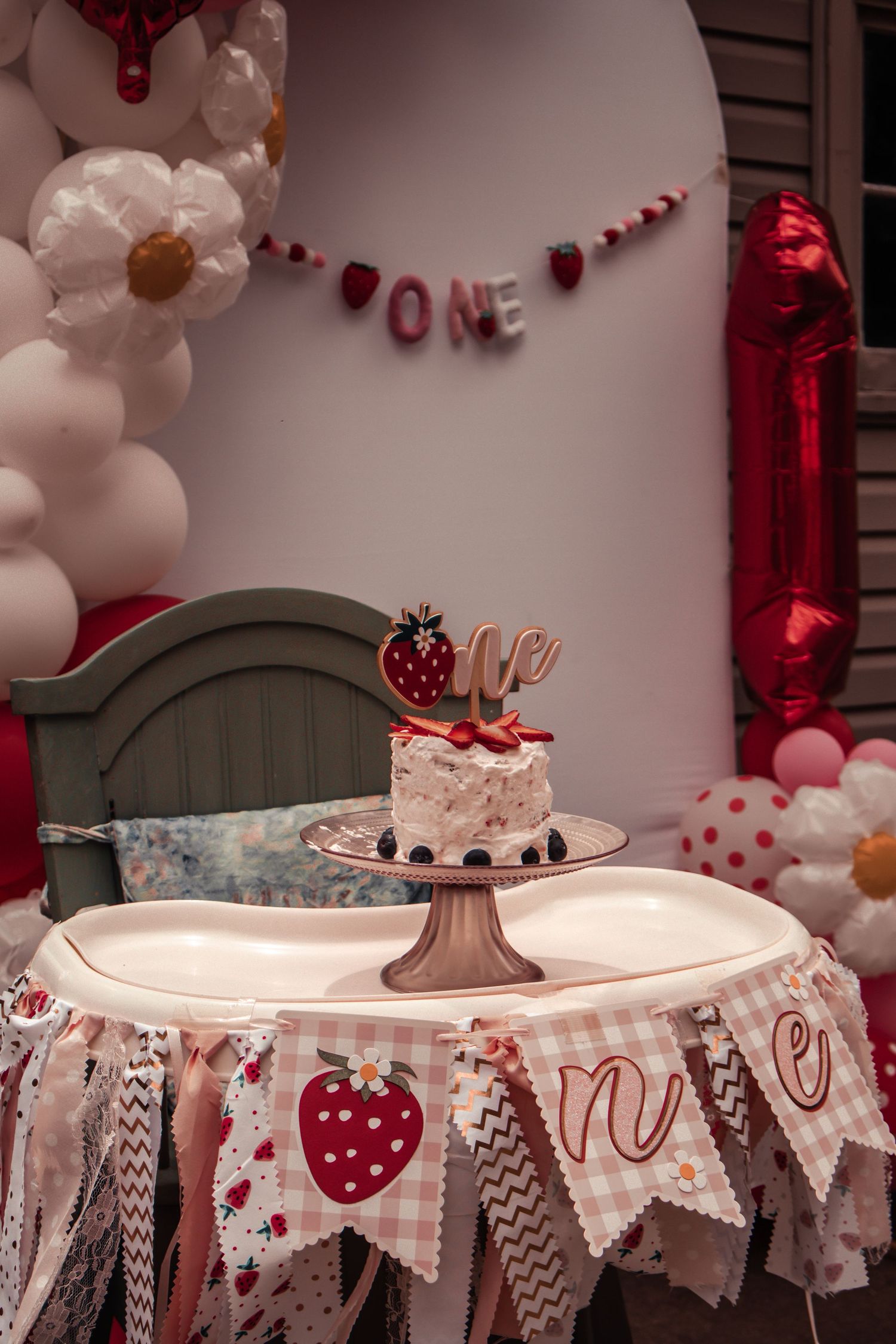 Pink and white party decorations with heart-patterned bunting and balloons.