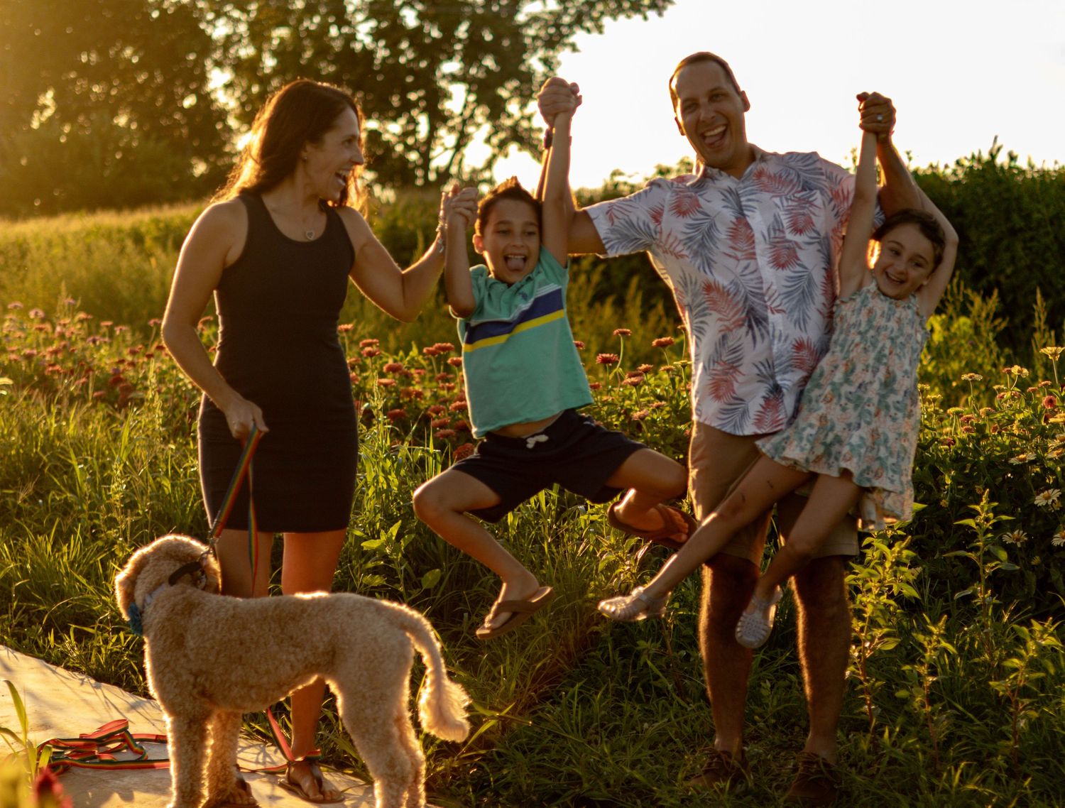 Family shares joyful moments together in sunlit summer field.