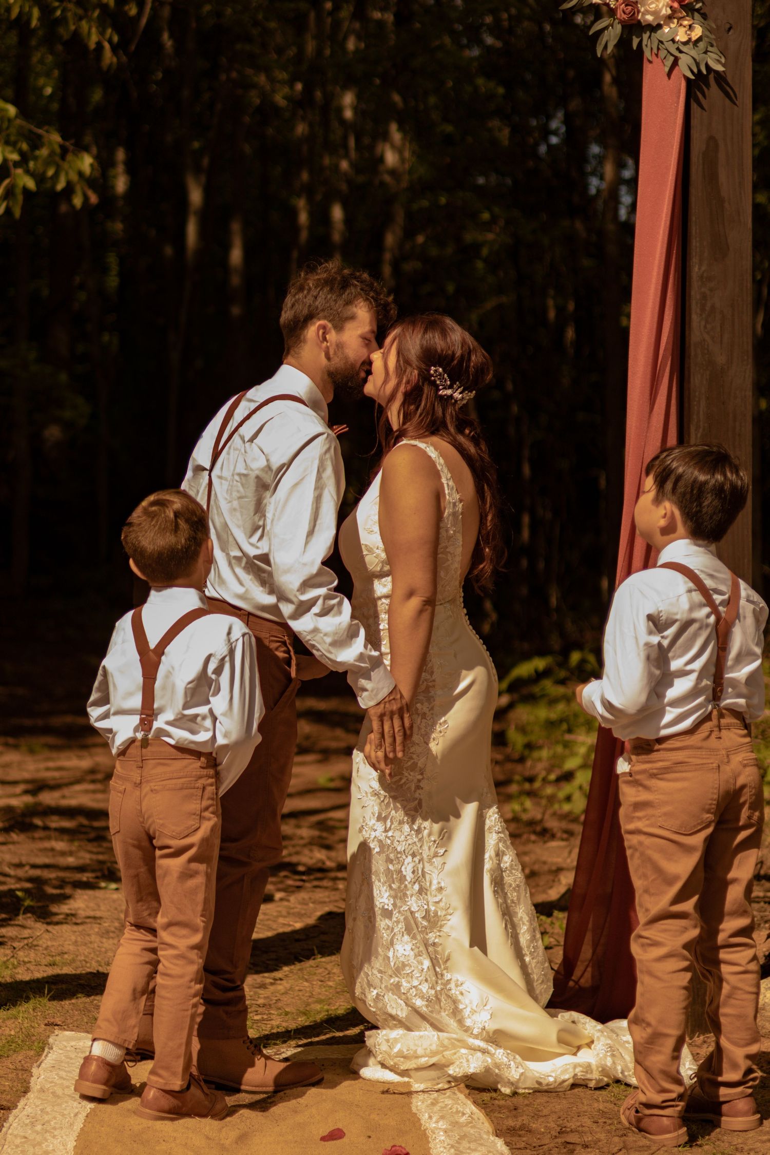 A sweet sequence of photos showing a small child in brown suspenders interacting with someone in a lace dress outdoors.