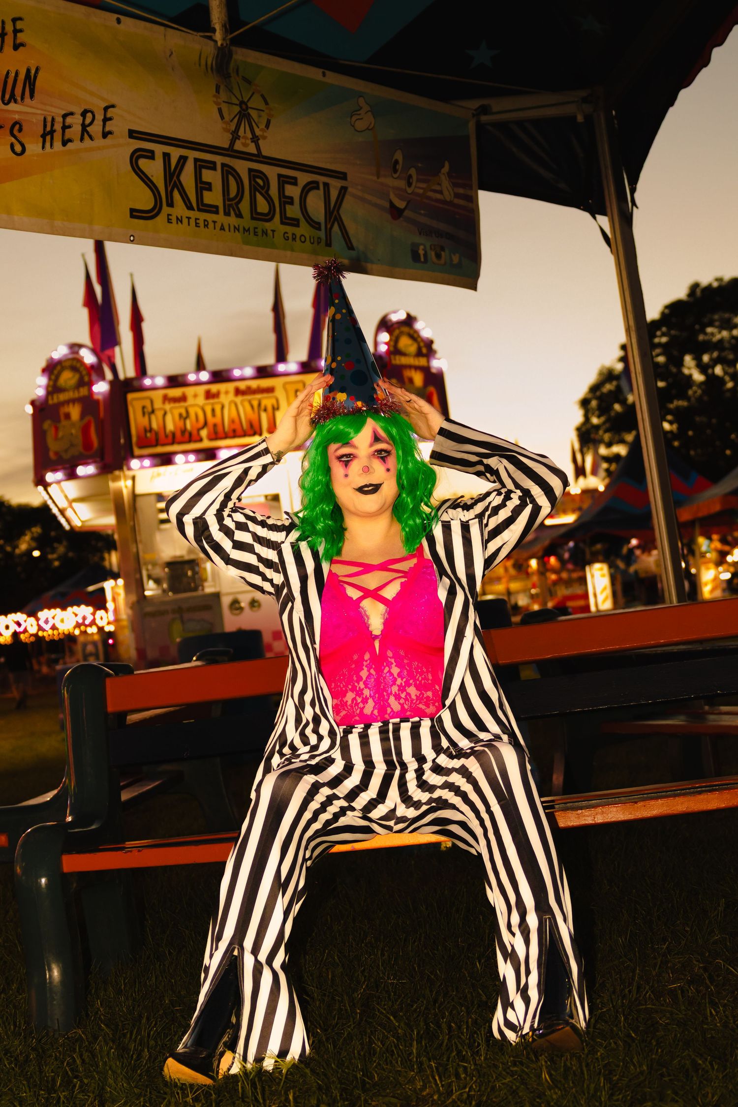 Person in Beetlejuice costume with green wig at Skerbeck carnival at night.