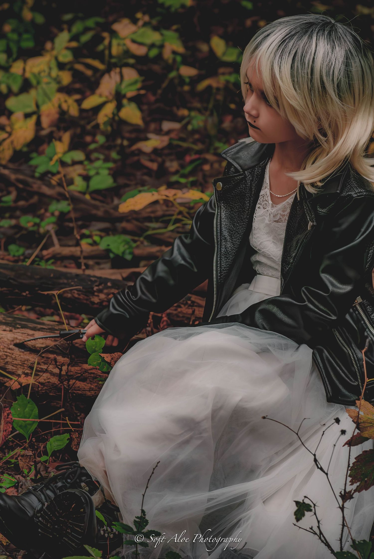 Moody forest photography series combining edgy leather with delicate white tulle dress details.