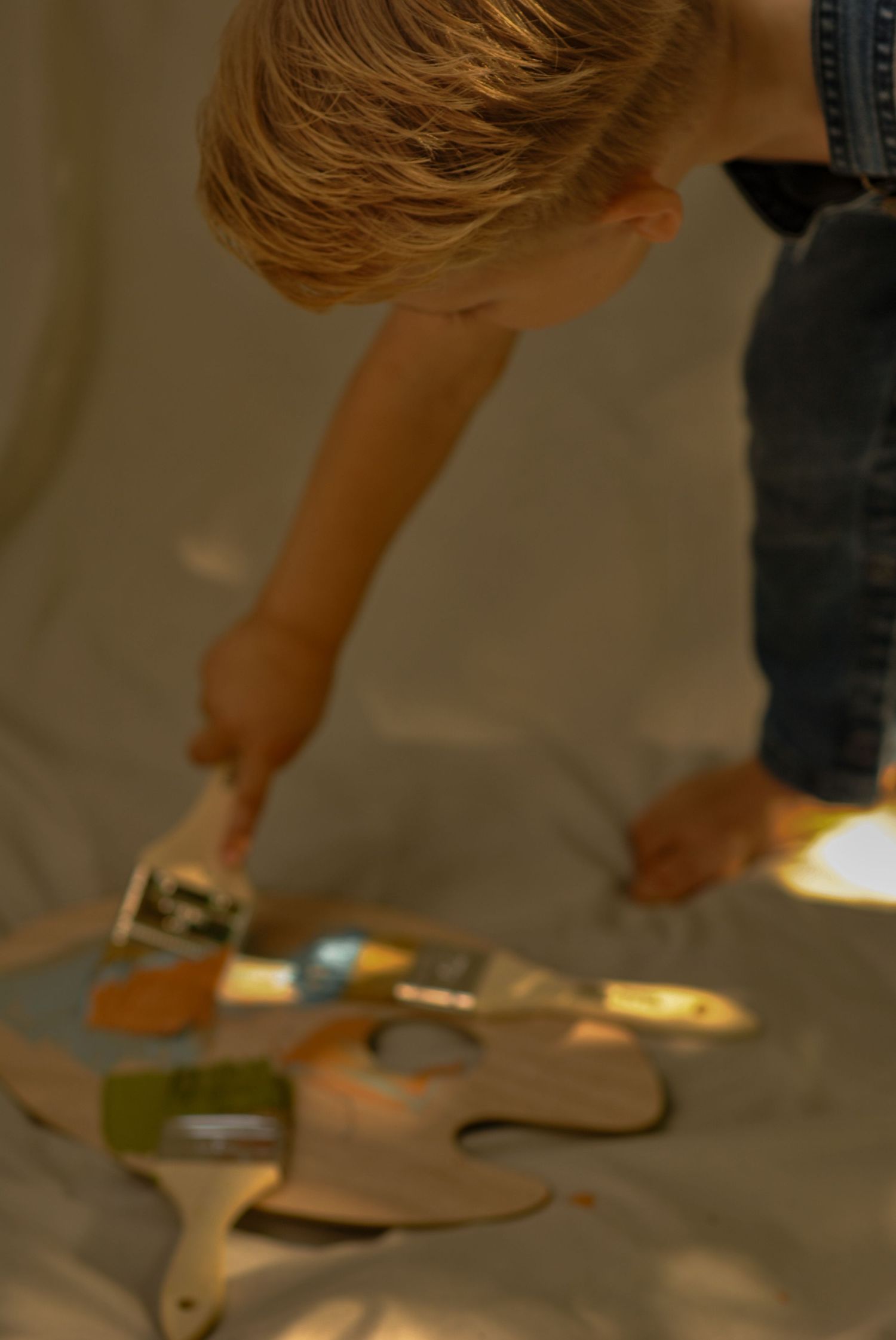 Close-up of hands reaching down to interact with objects on the floor.