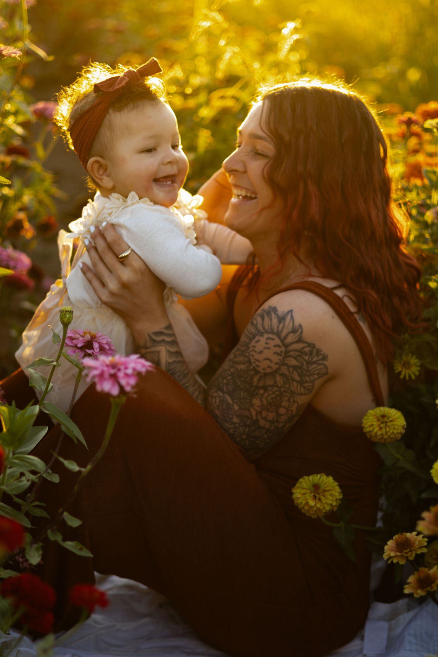 Parent and child share tender moments in a golden sunlit garden with blooming flowers.