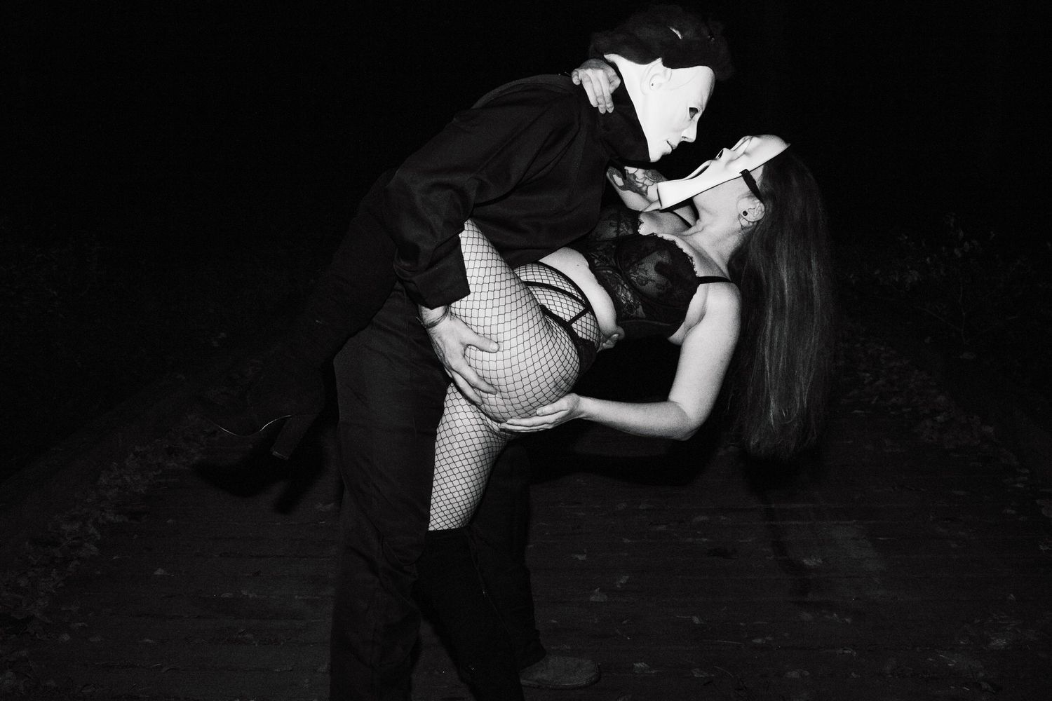 Dramatic black and white photo of dancers performing an intimate tango dip pose.
