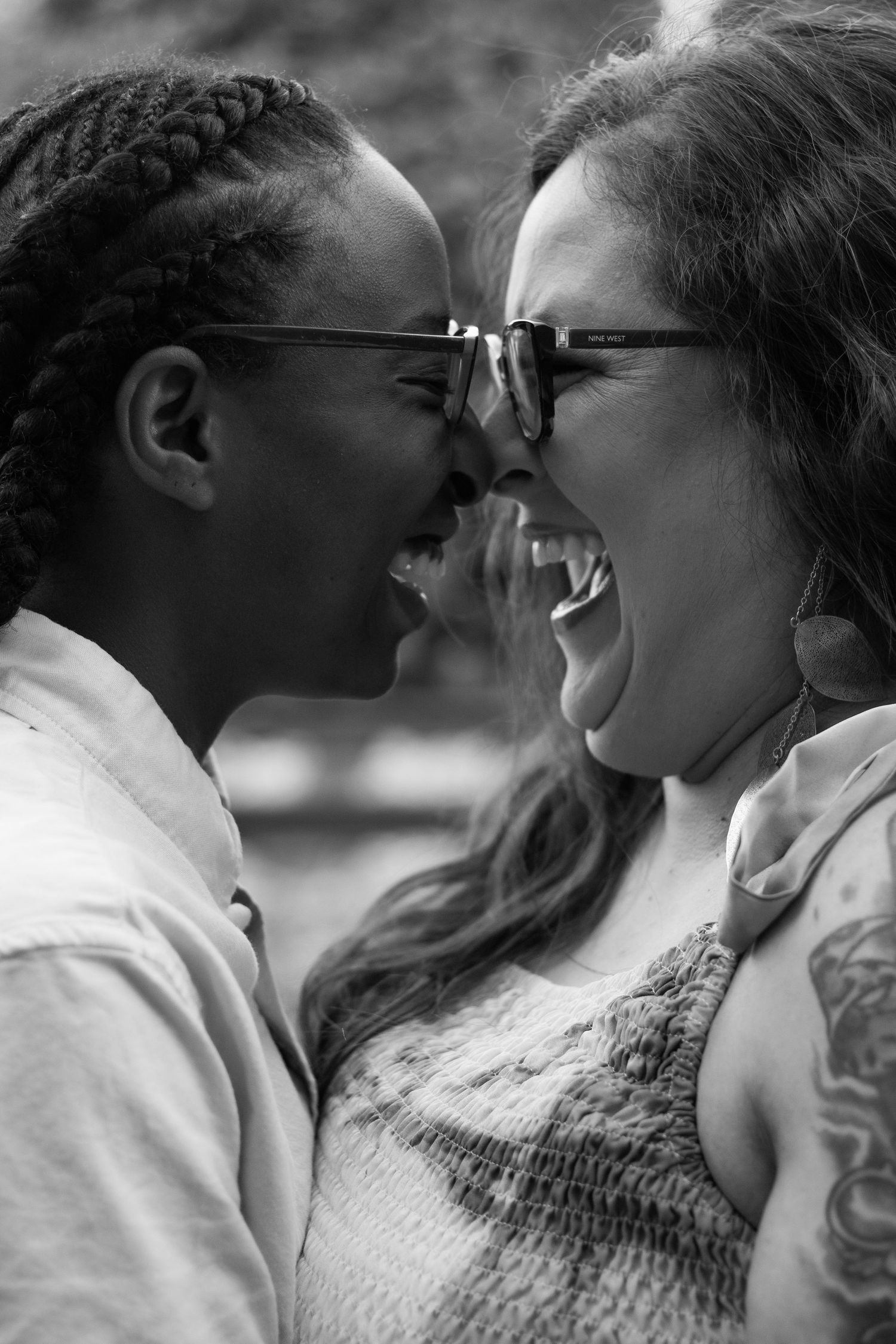 Close-up black and white photo of joyful couple sharing intimate moment outdoors.