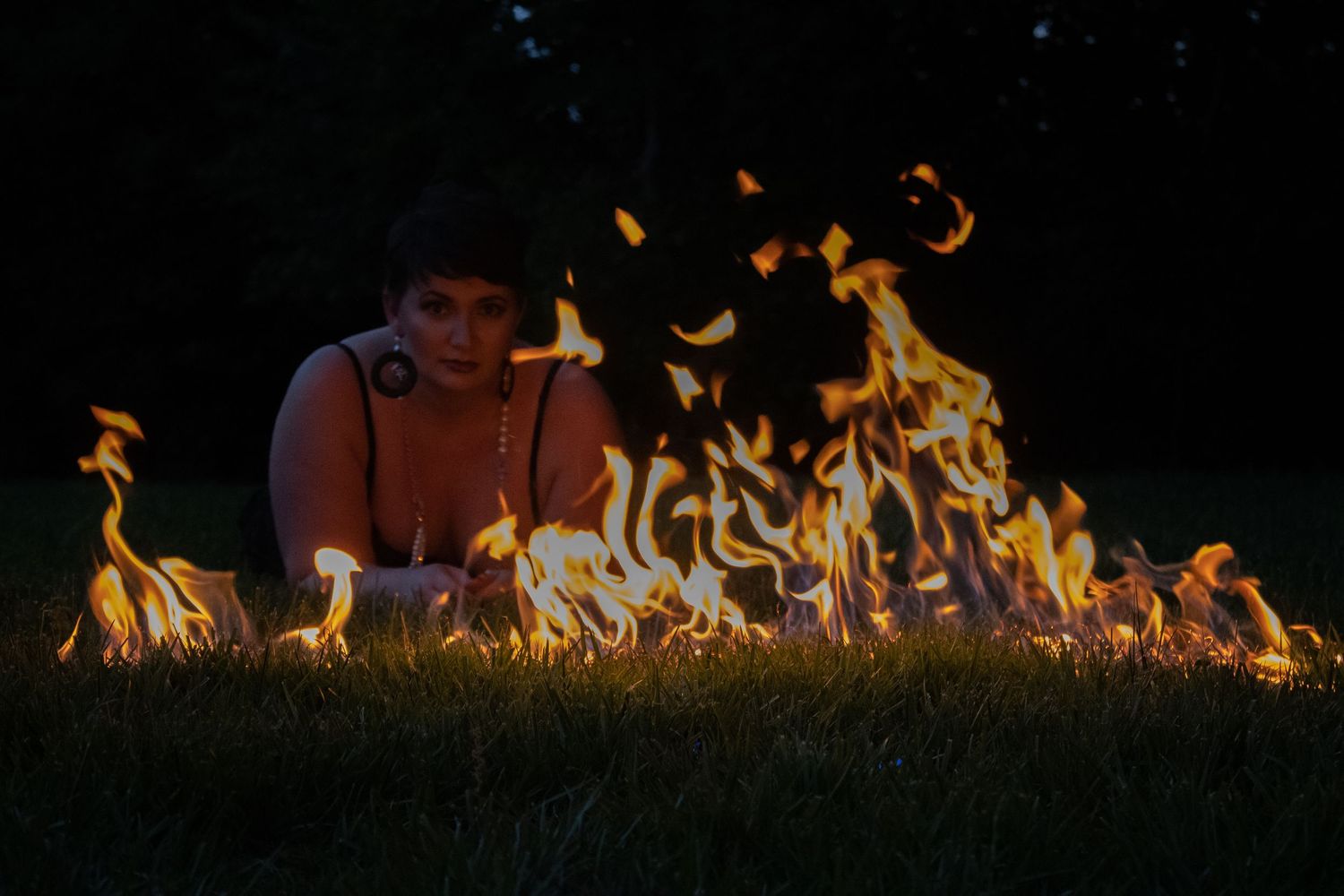 Dramatic nighttime portrait with line of fire flames in the foreground.