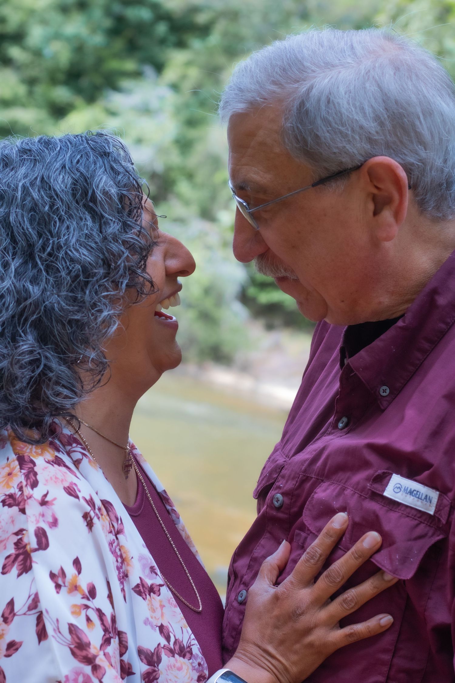 Two people having an intimate conversation outdoors dressed in burgundy and floral patterns.