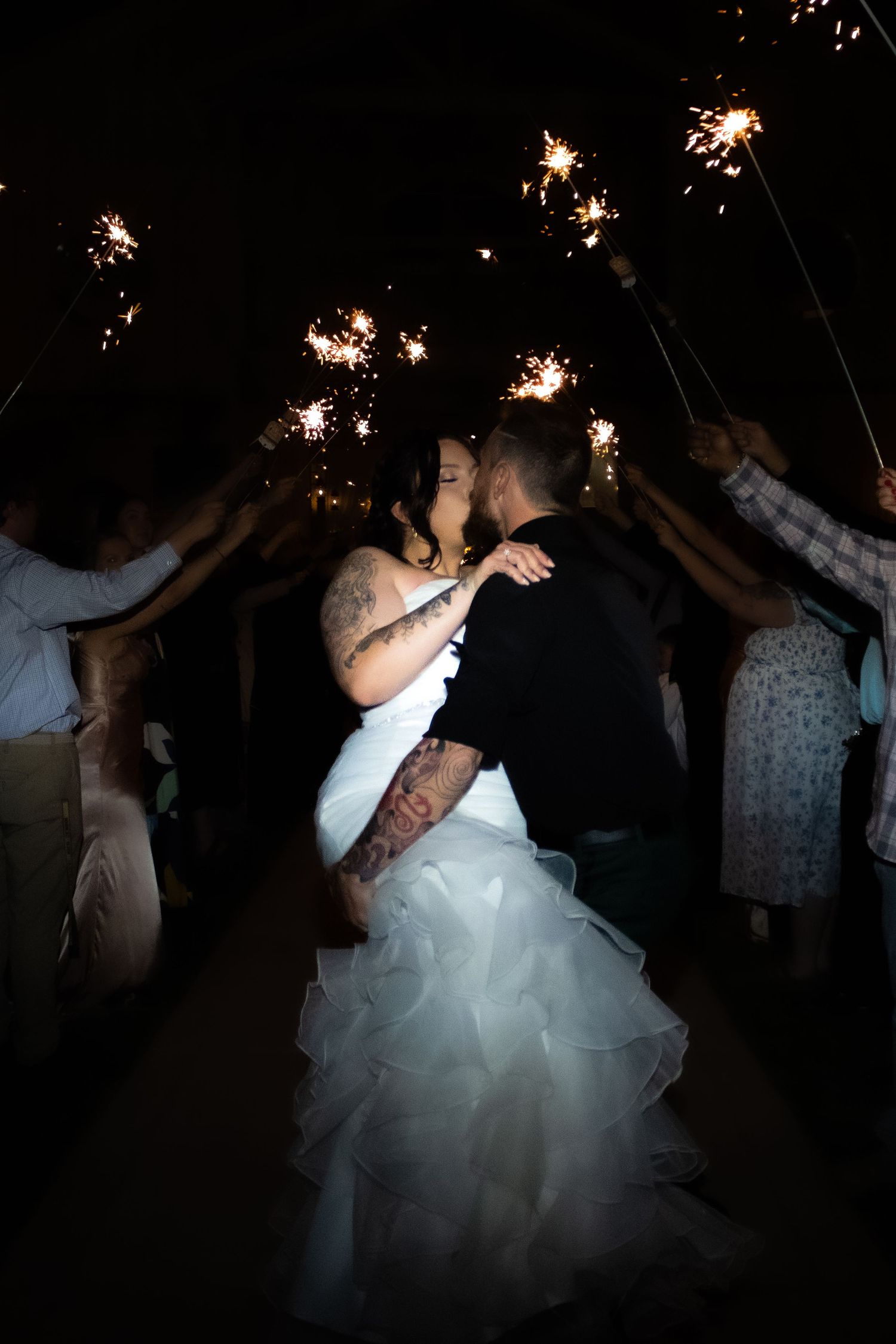 Wedding celebration with sparklers creating magical light trails in the darkness.