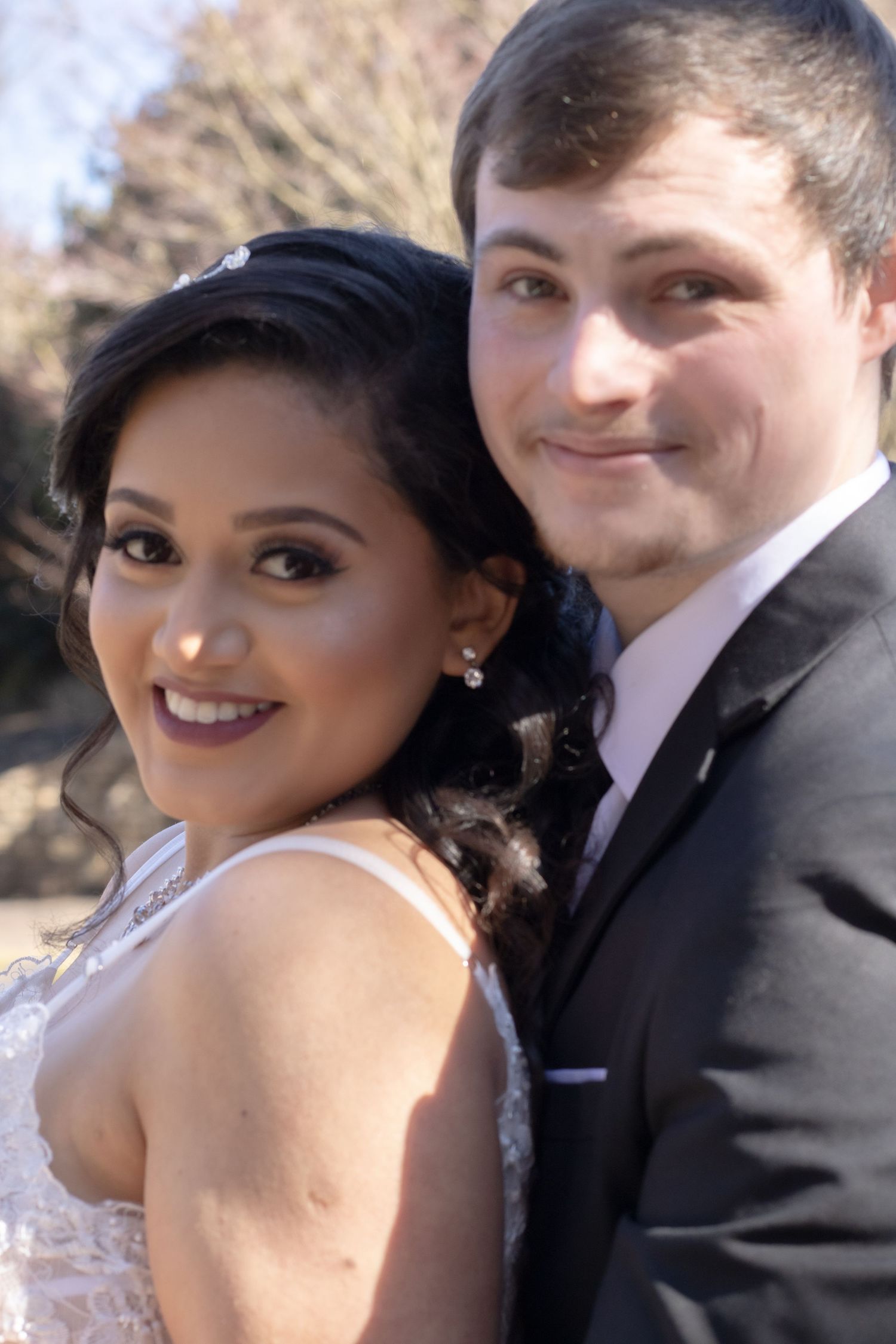 Wedding portrait of happy couple outdoors in formal attire.