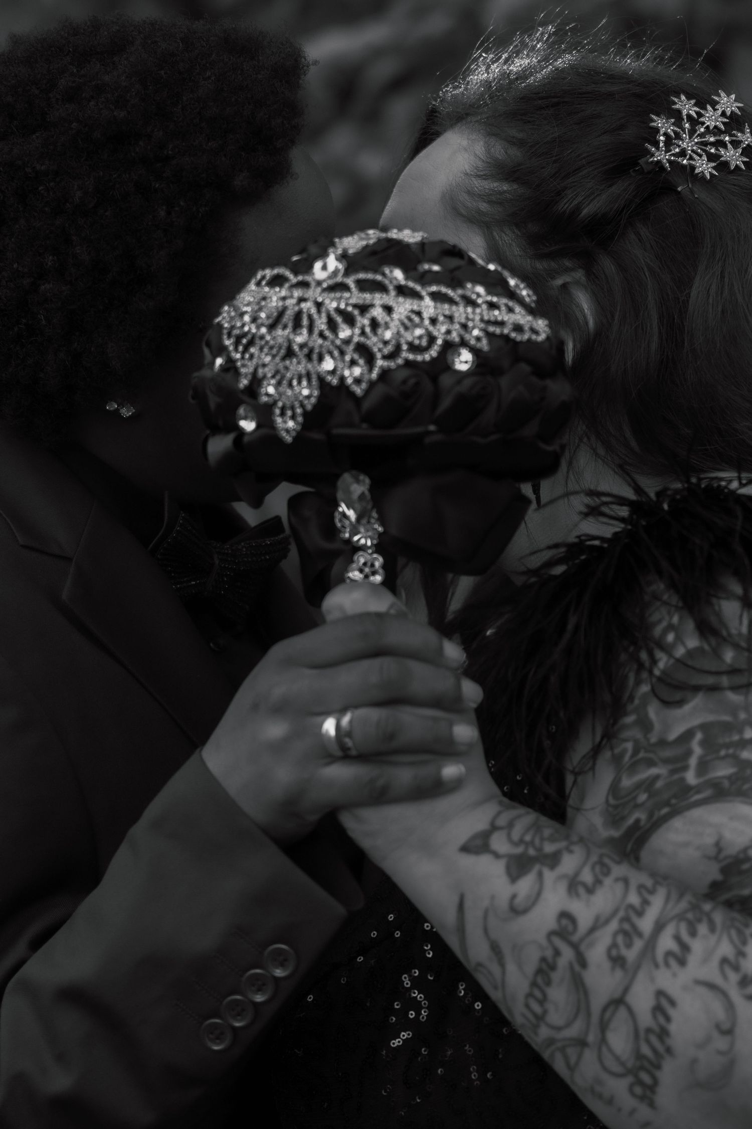 An intimate moment captured with ornate bridal headpiece and clasped hands in black and white.