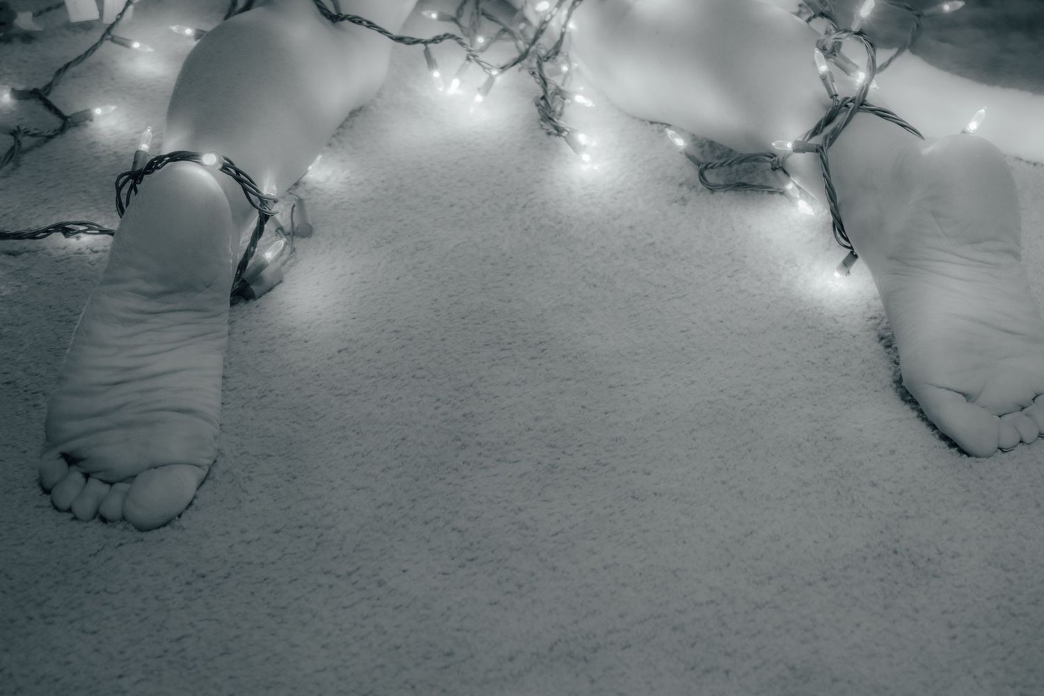 String lights creating bokeh effect against snowy white surface.