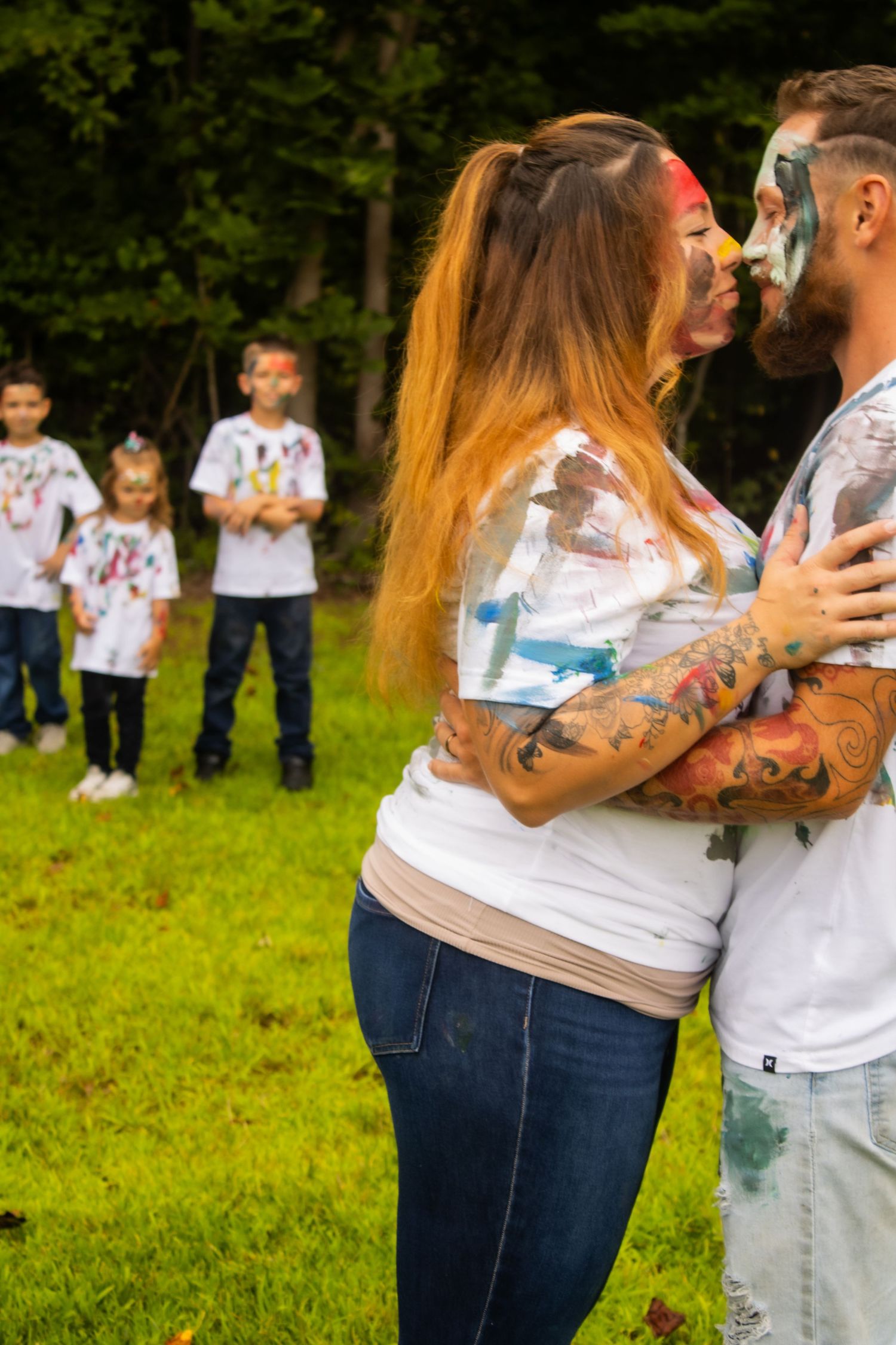 Couple covered in colorful powder paint embracing during an outdoor photoshoot.