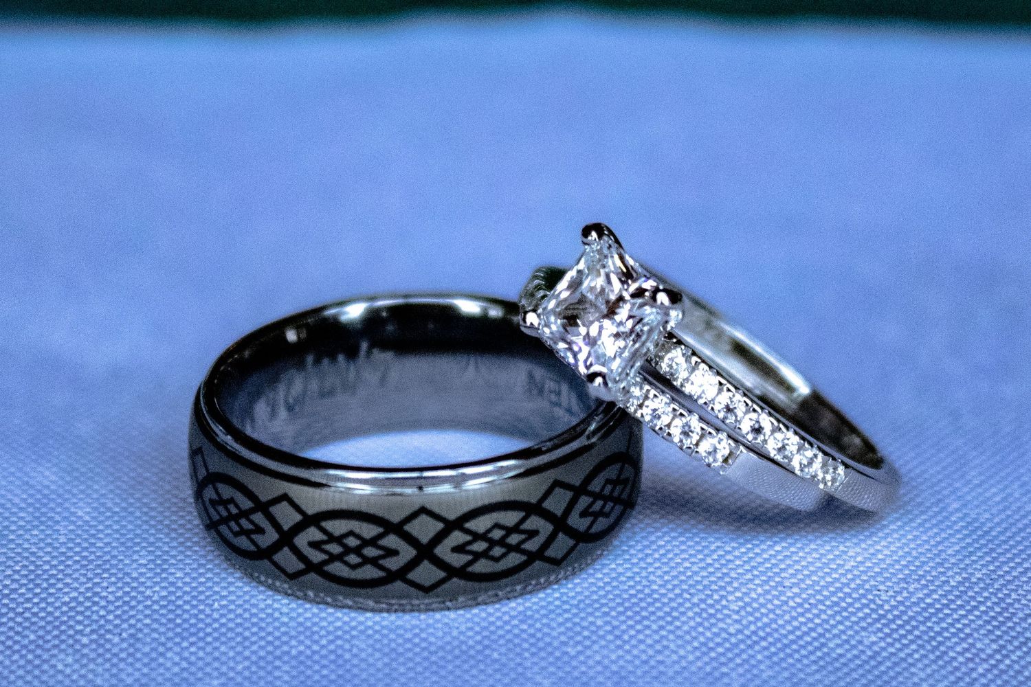 Wedding rings with Celtic designs displayed on a blue background.