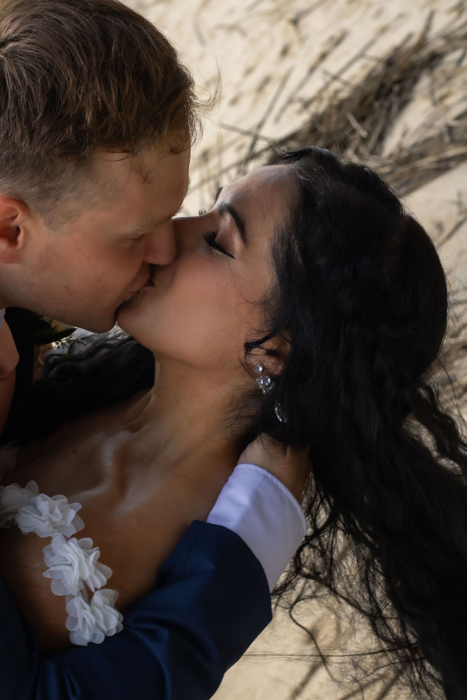 Artistic close-up shot of newlyweds sharing a passionate kiss.