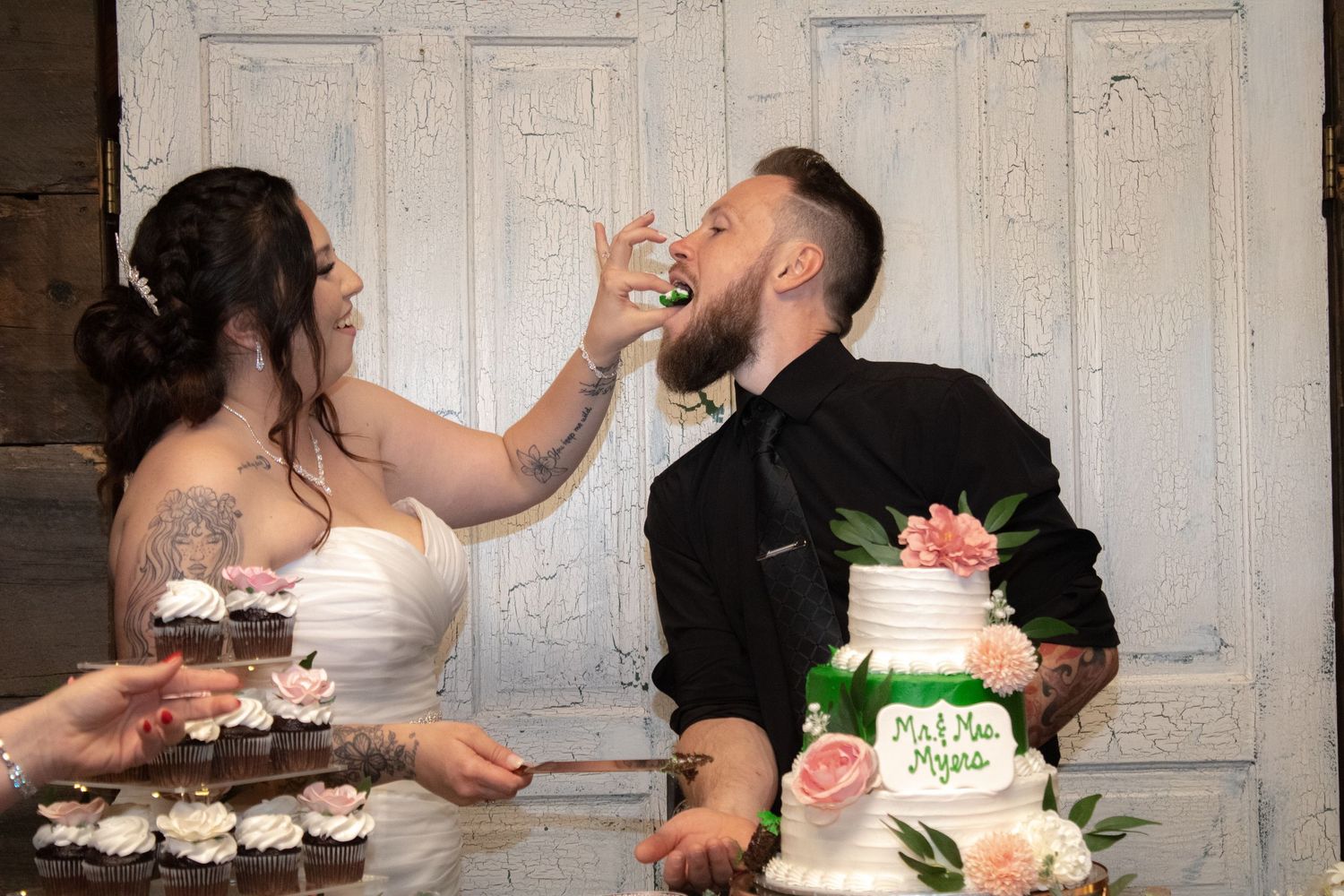 Wedding couple sharing cake during traditional cake cutting ceremony.