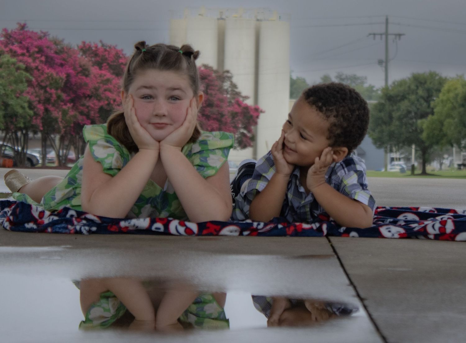 Two children laying on their stomachs and resting chins on hands.