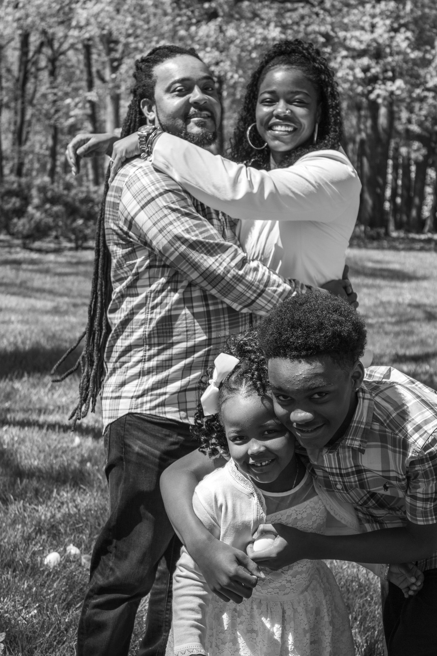 A black and white photo of a loving family enjoying springtime outdoors together.
