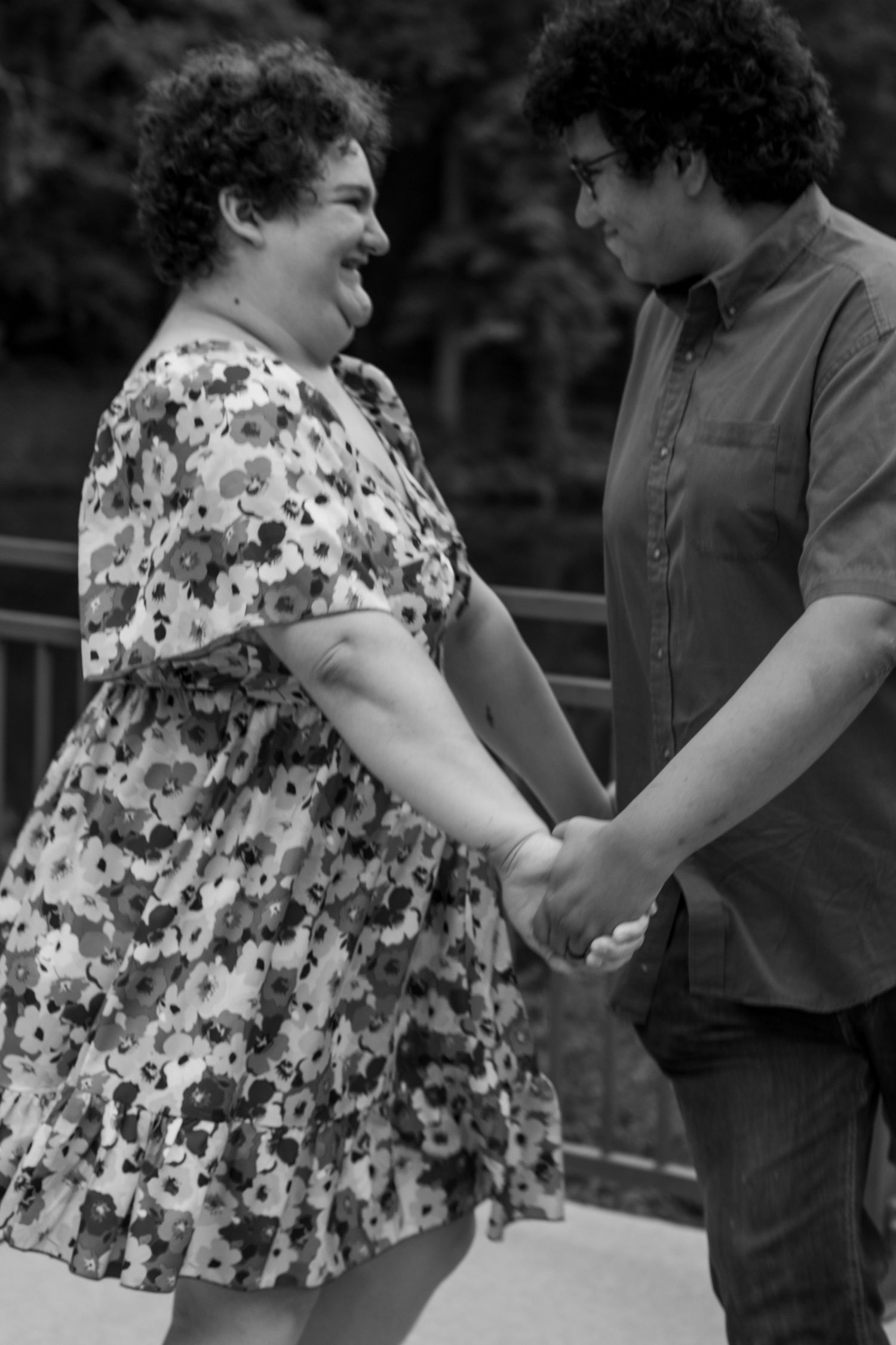 A black and white photo showing two people in casual attire sharing a lighthearted moment.