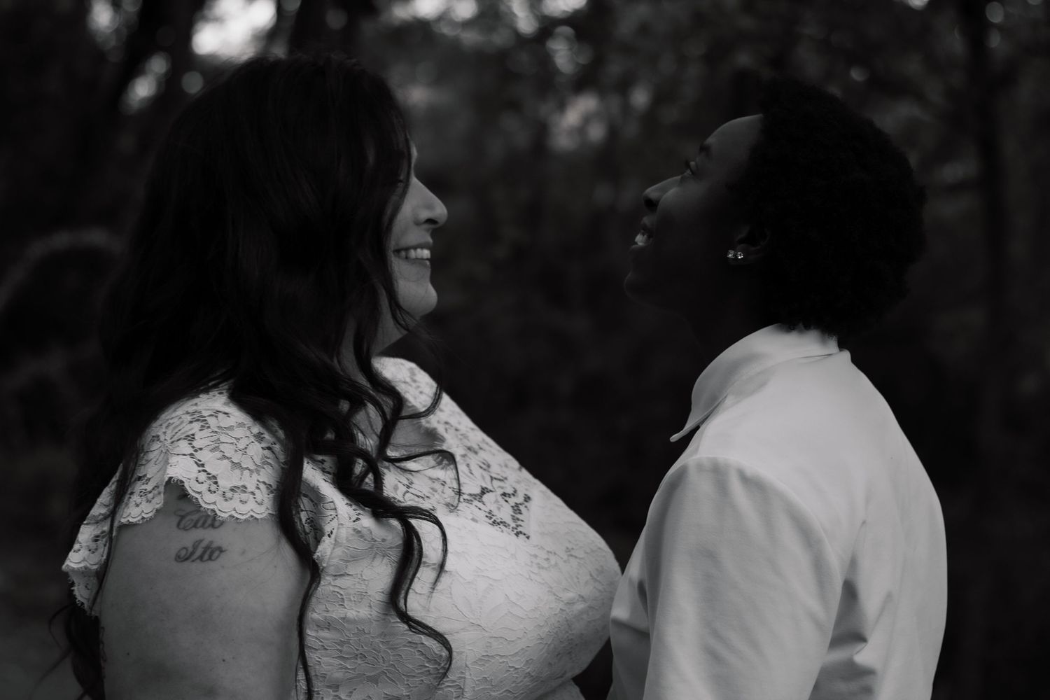 A romantic couple in wedding attire share a joyful moment during their outdoor celebration.