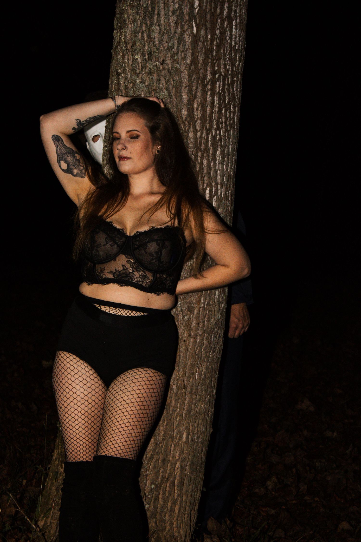 Moody portrait against tree trunk with black lace and fishnet details.