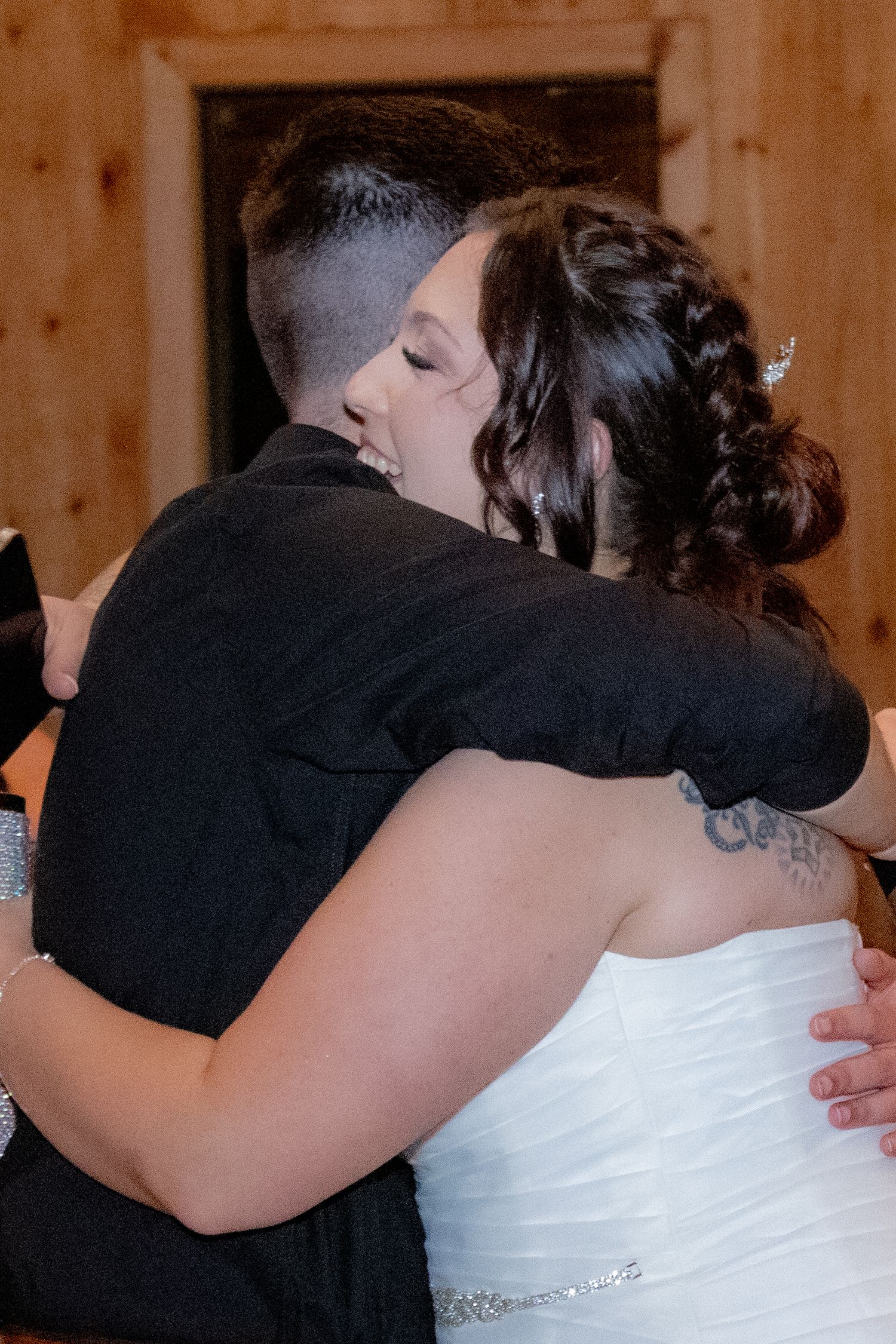 Couple sharing an intimate dance embrace at their rustic indoor wedding celebration.