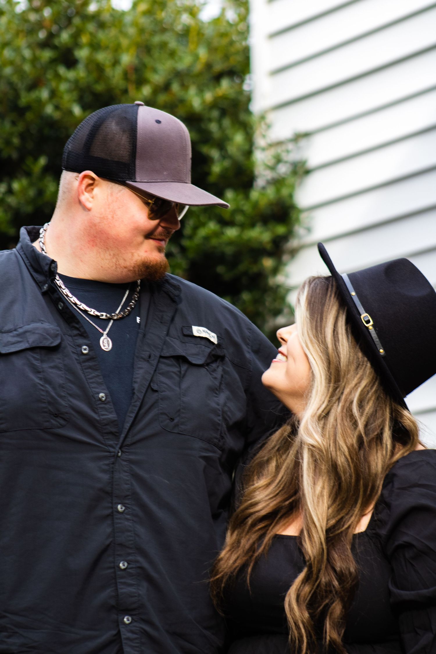 Couple in casual black outfits sharing an intimate moment outdoors.
