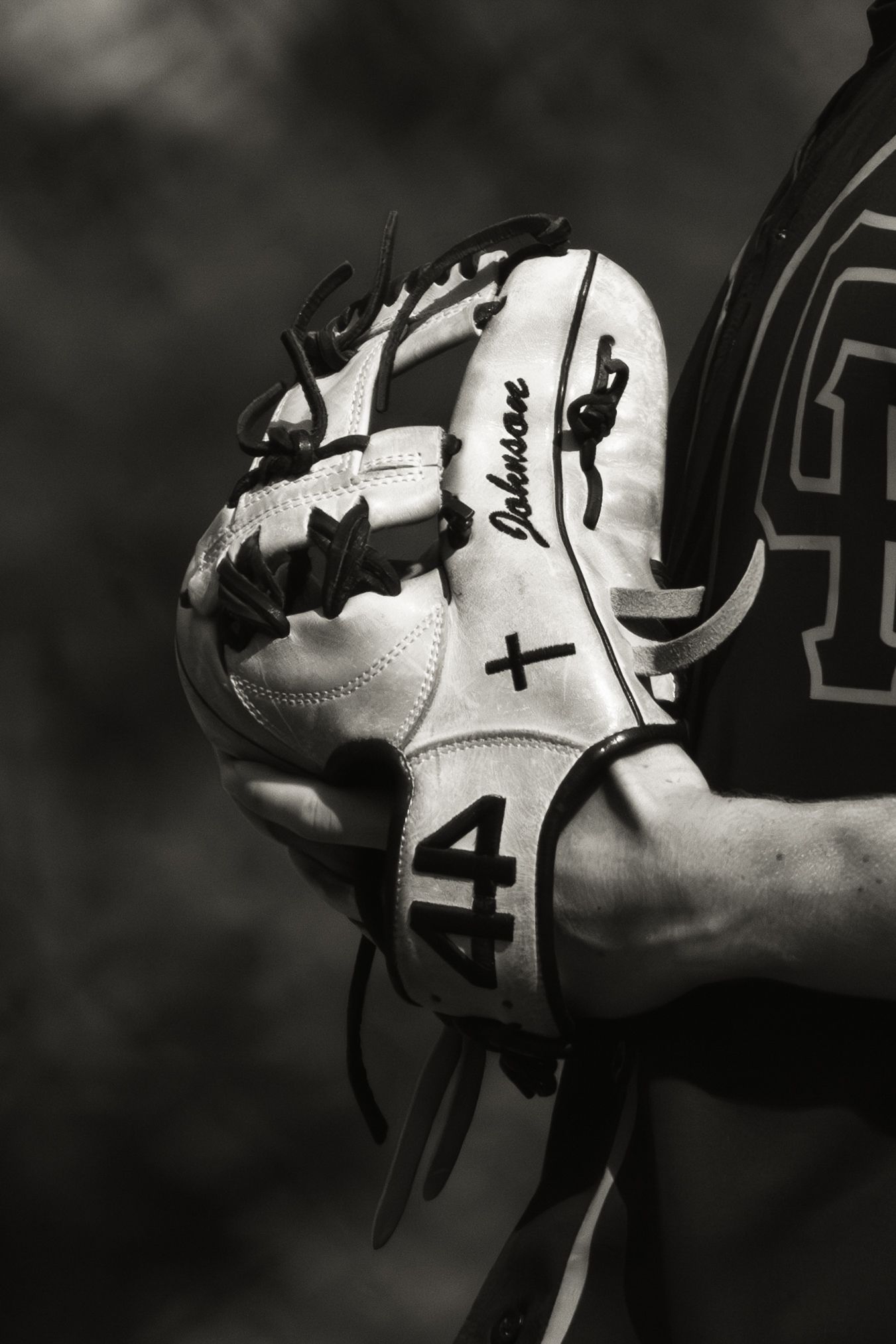 Close-up black and white photo of baseball glove with number 44.