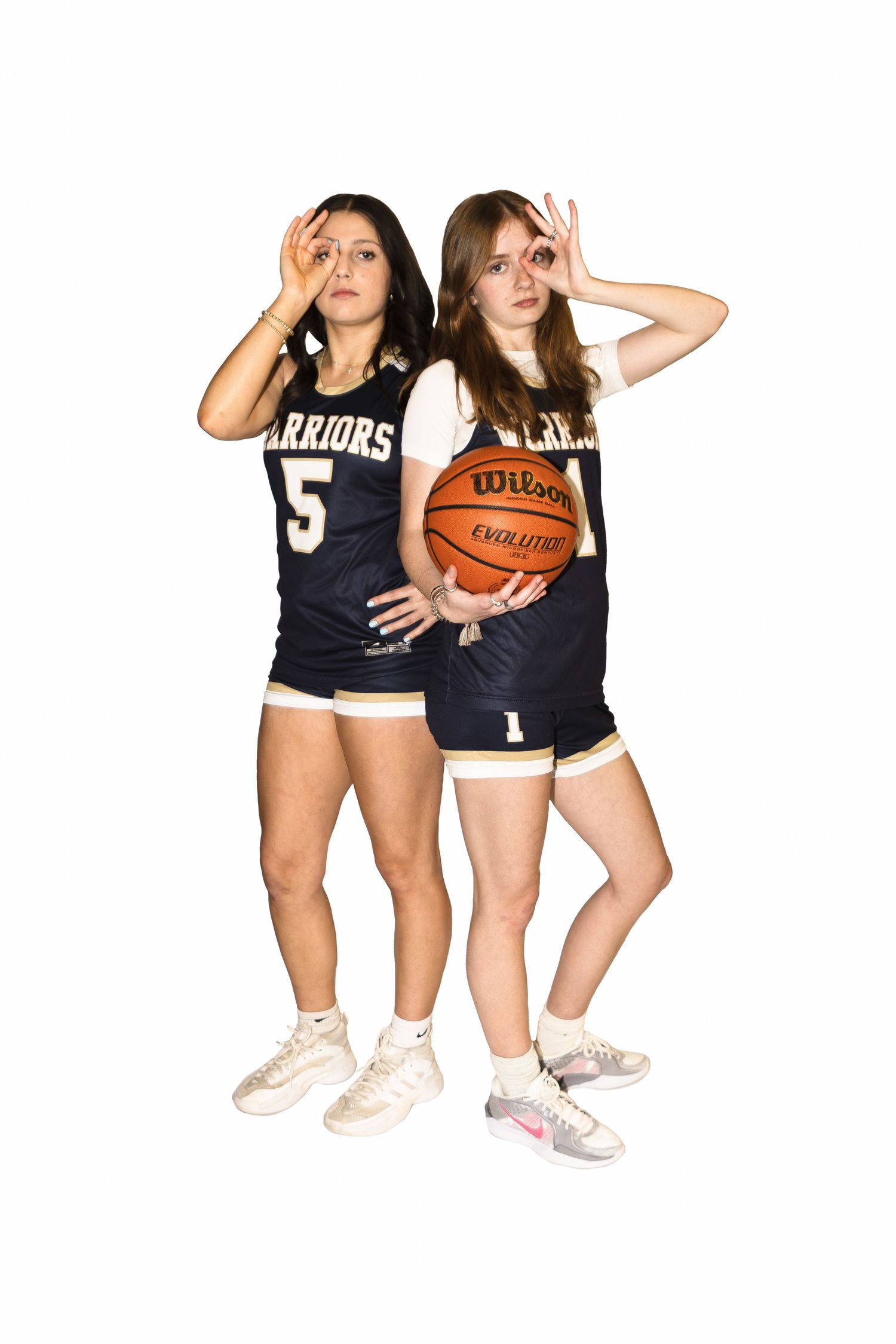 Two basketball players in navy Warriors jerseys numbered 5 pose together with a basketball against white background.