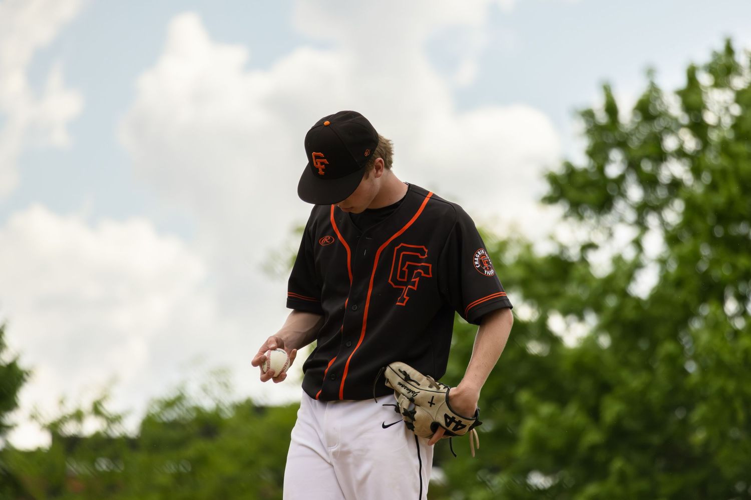Baseball players in dark uniforms practicing on a sunny field.