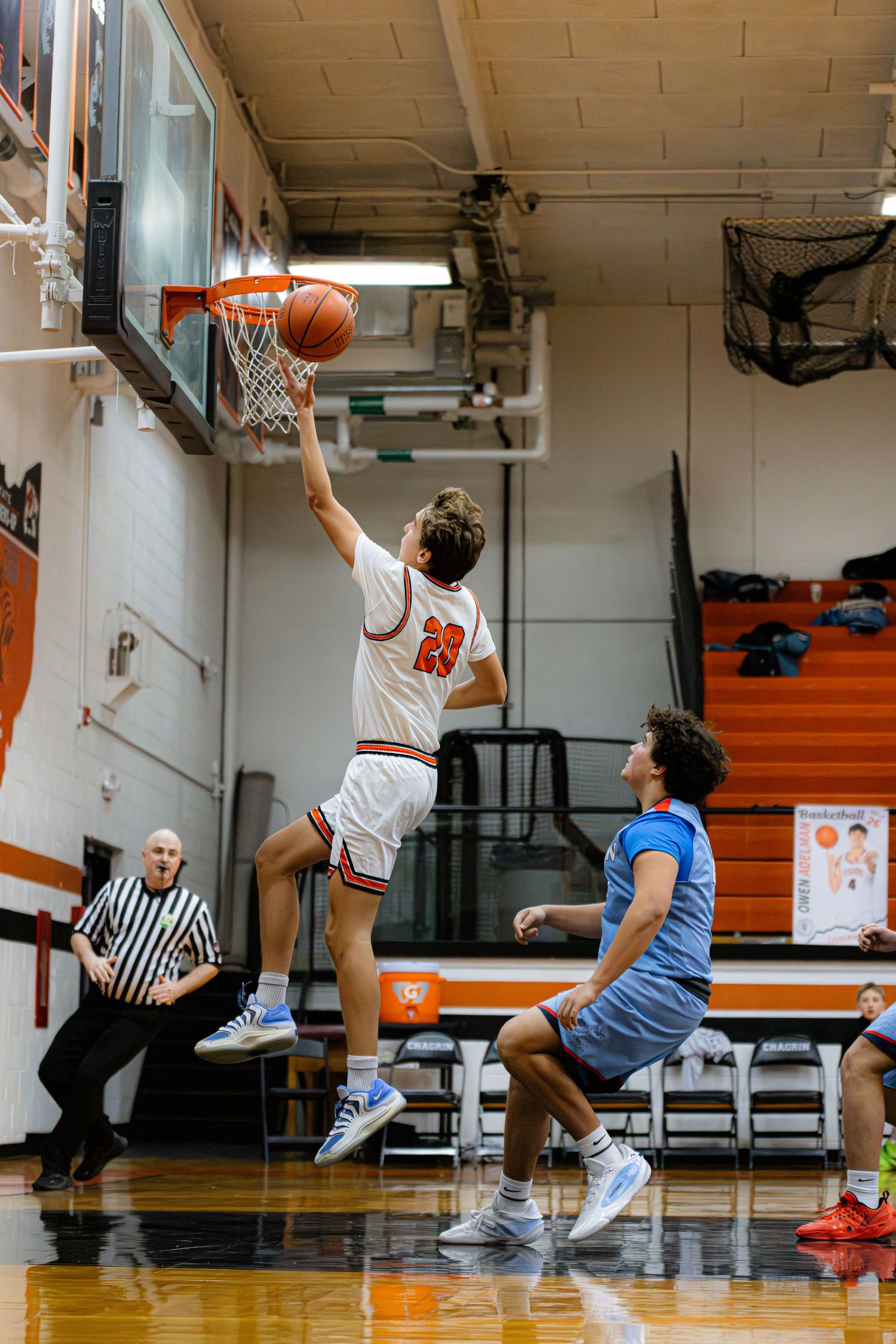 Multiple frames showing a basketball player in white jersey making a layup shot in a gymnasium sequence.