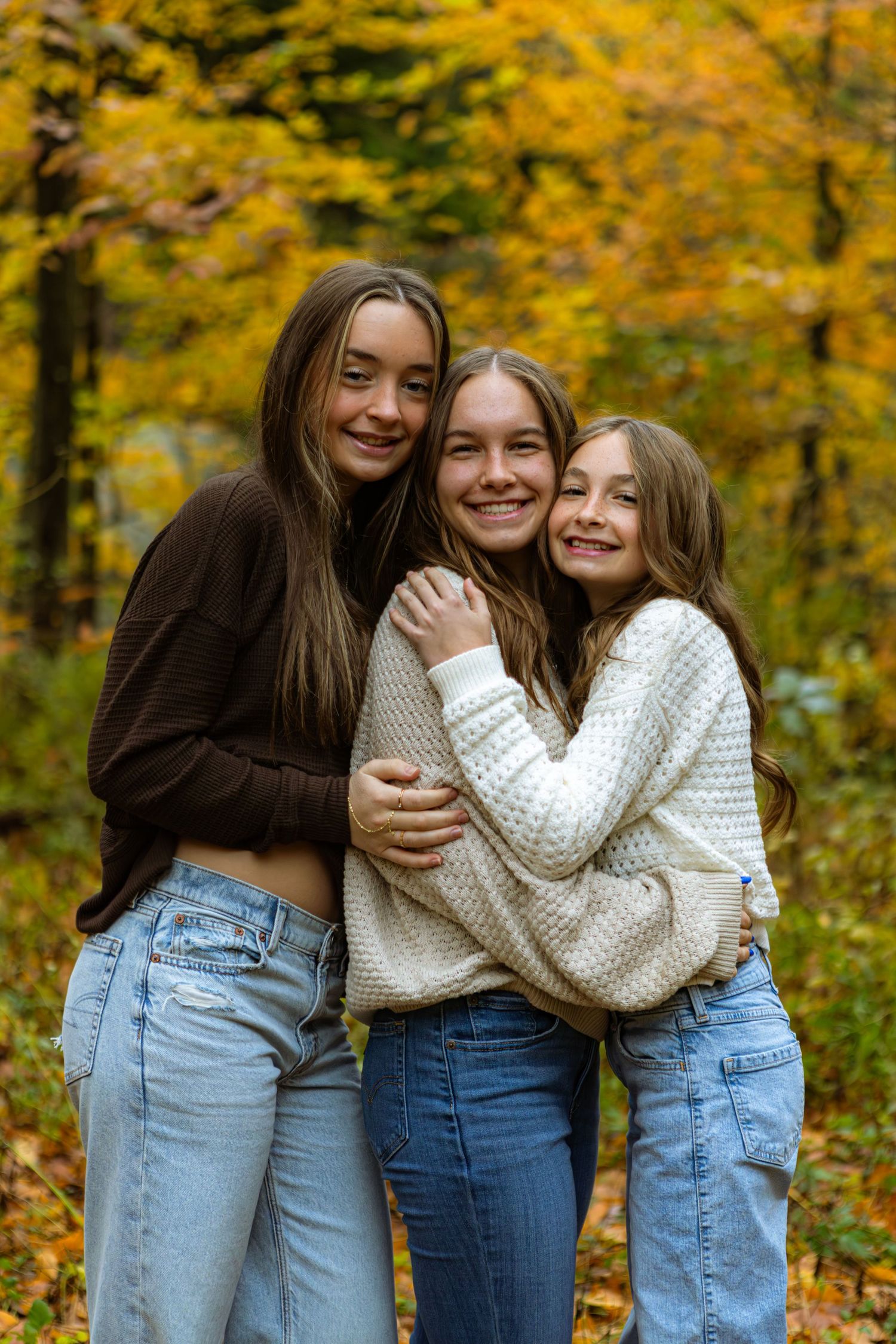 Friends share joyful moments together against a backdrop of vibrant autumn foliage in a park setting.