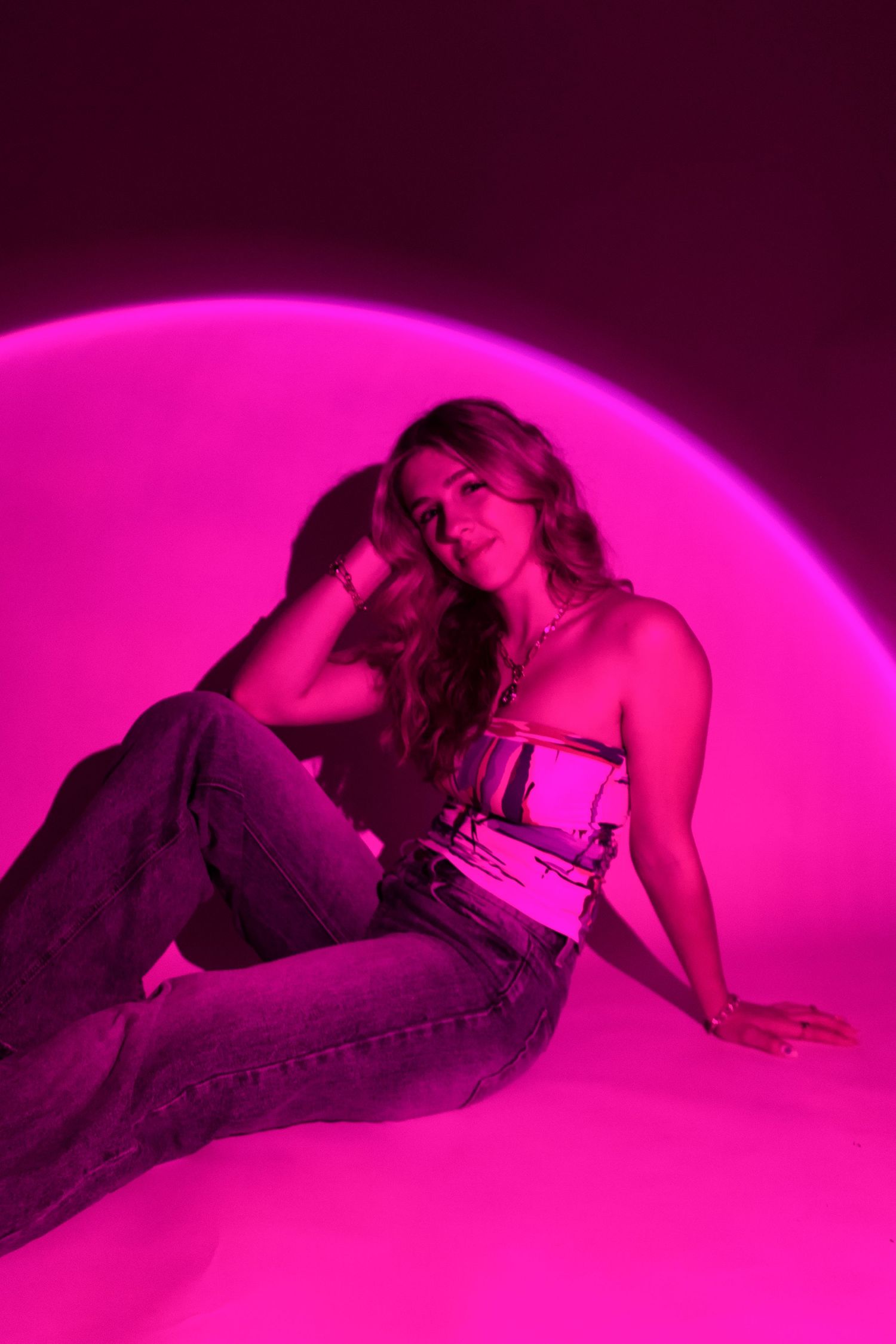 Artistic sequence of silhouettes lying down with pink neon lighting creating a dramatic atmospheric effect.