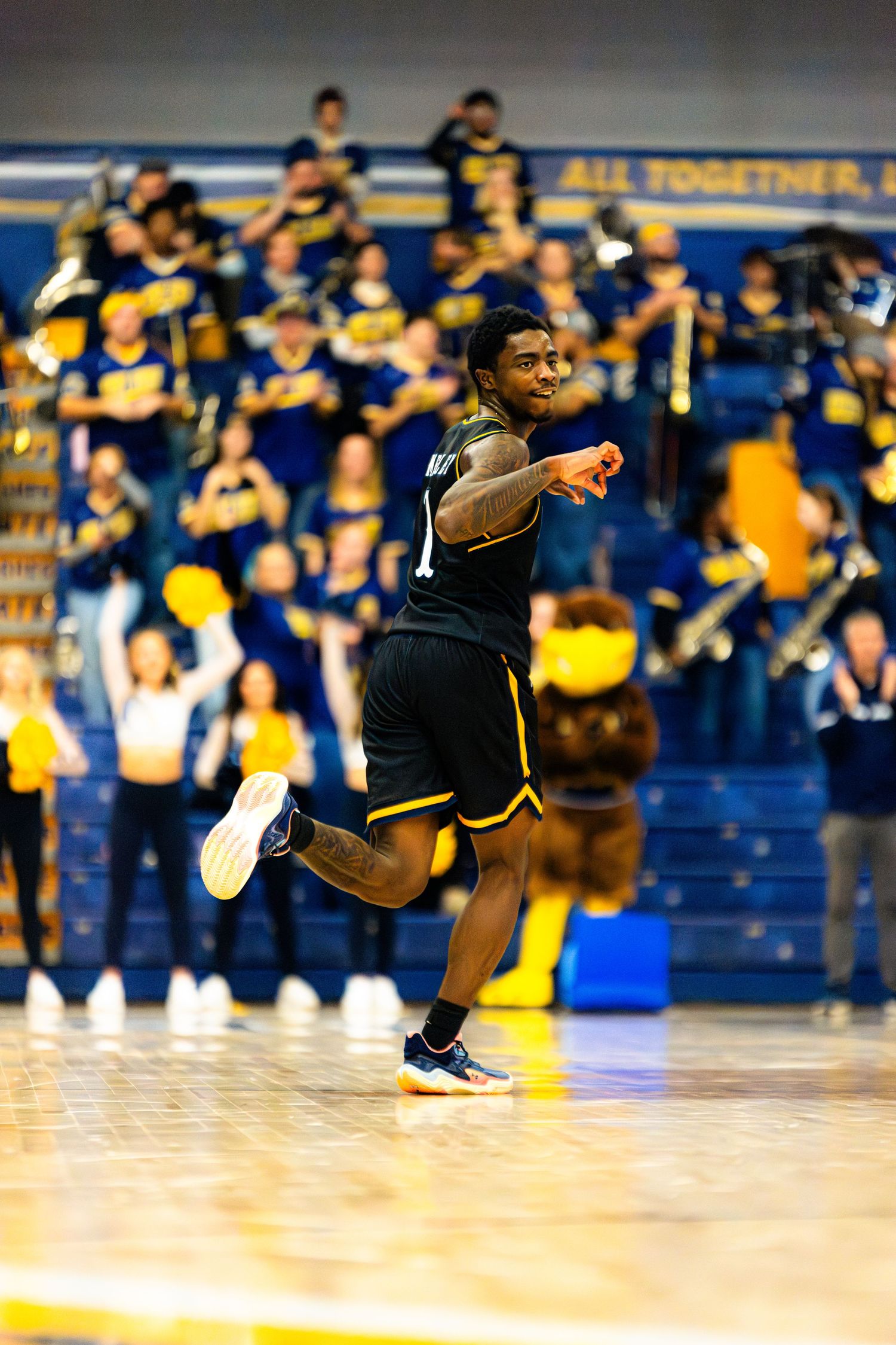 Break dancer performs dynamic spinning move on basketball court during halftime show.