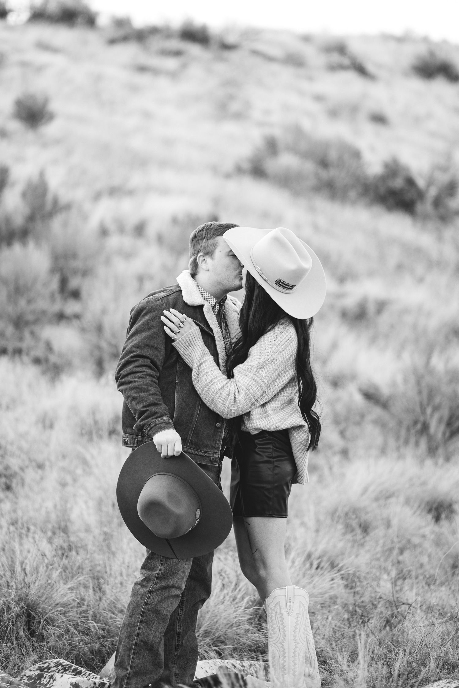 couple celebrate their recent engagement with a kiss in the boise foot hills