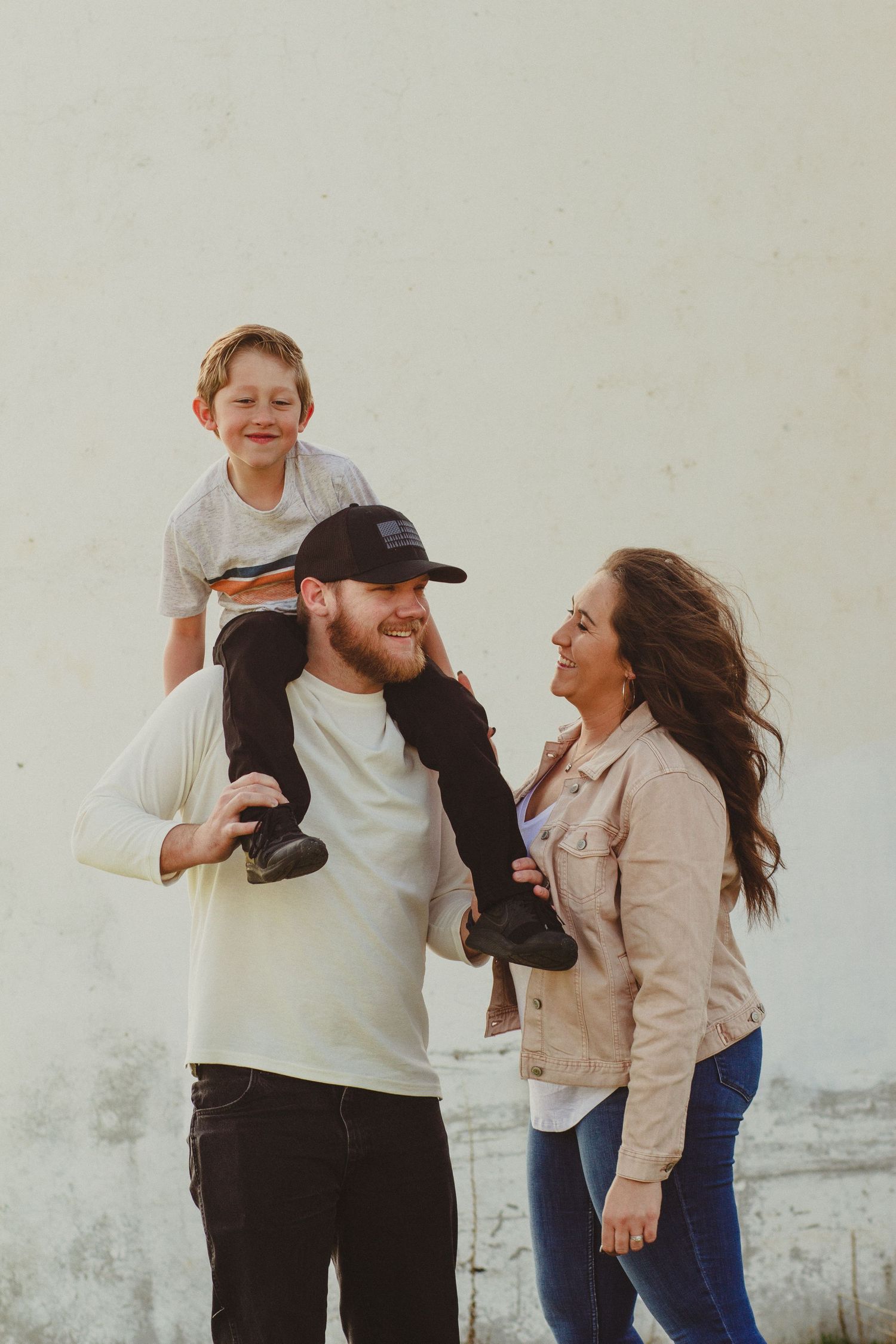 Father son and mother enjoy the fall air with each other as they pose for family photos in Eagle Idaho