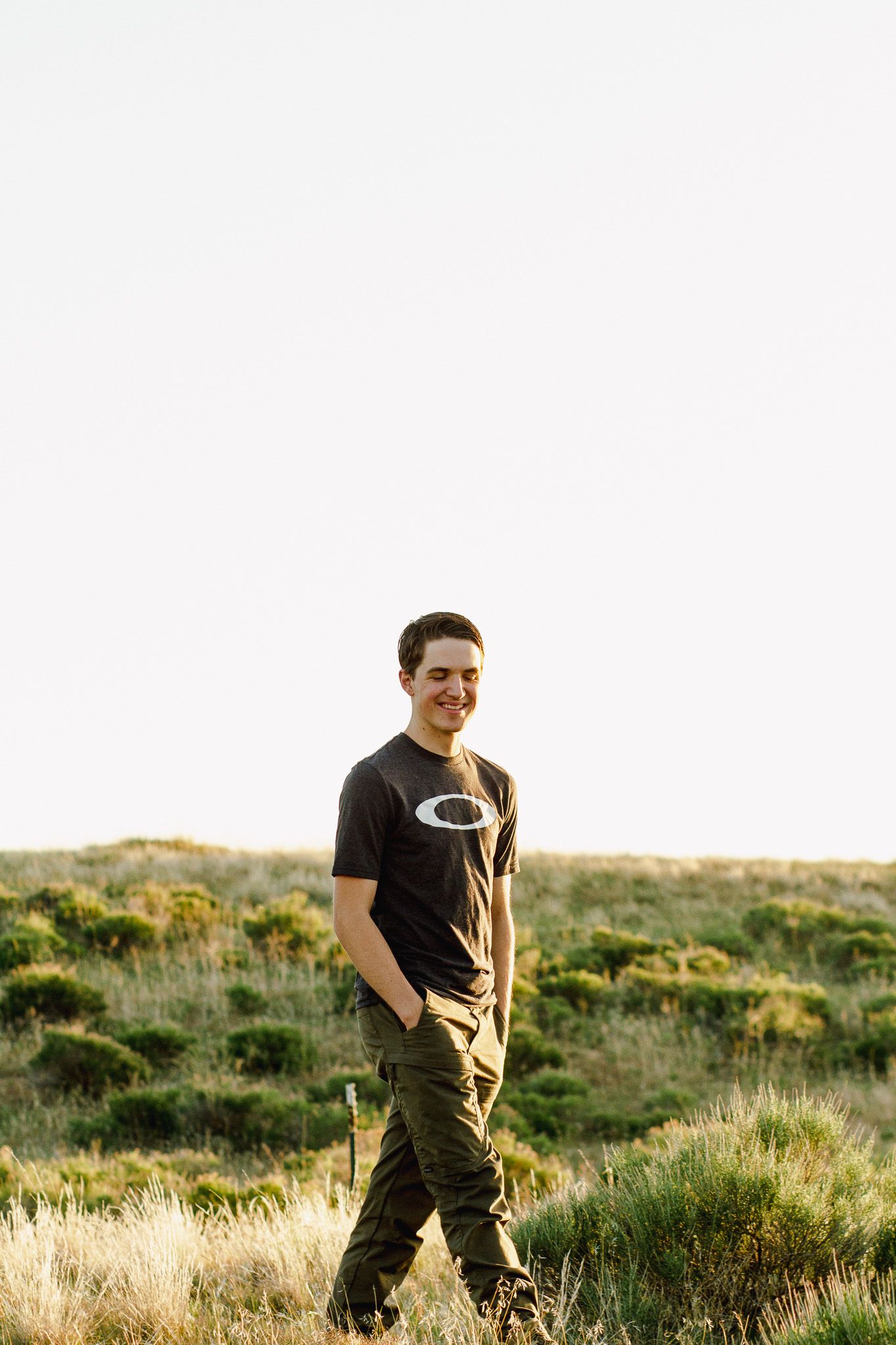 this photo shows a young man walking though the sage brush in the golden summer sun in eagle Idaho