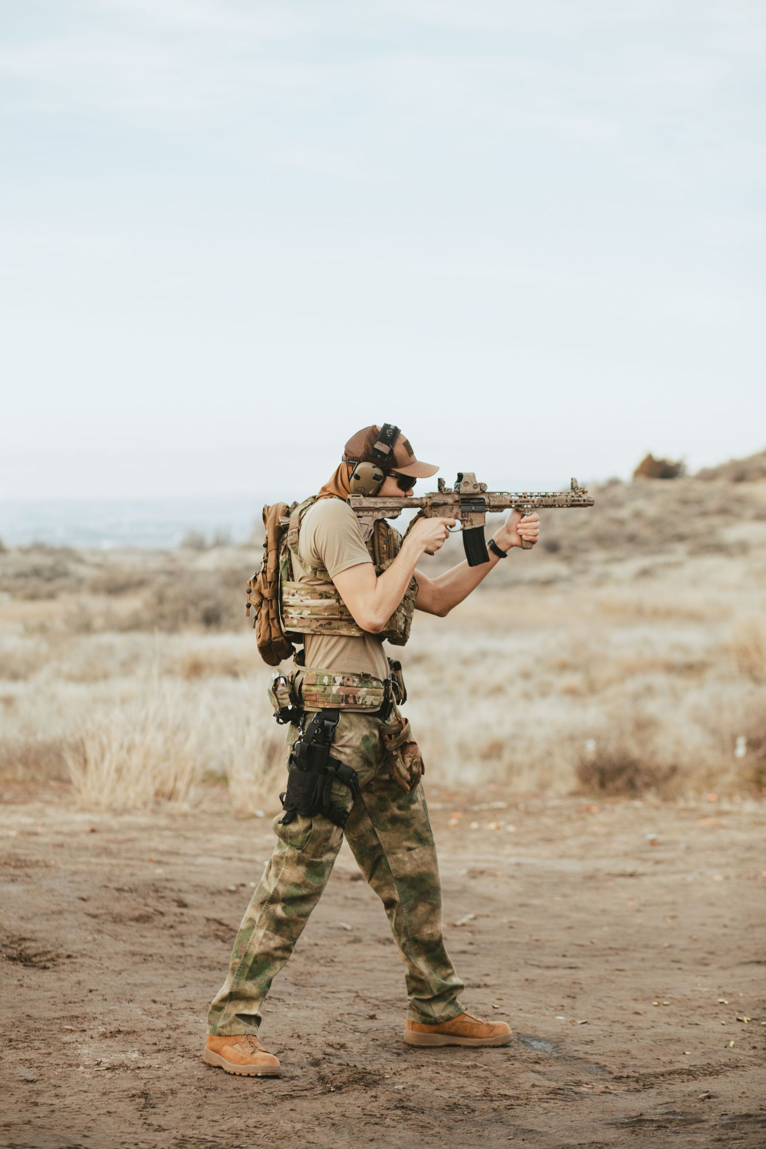 Soldier in tactical gear and camouflage pants aims rifle in desert training environment located in boise Idaho