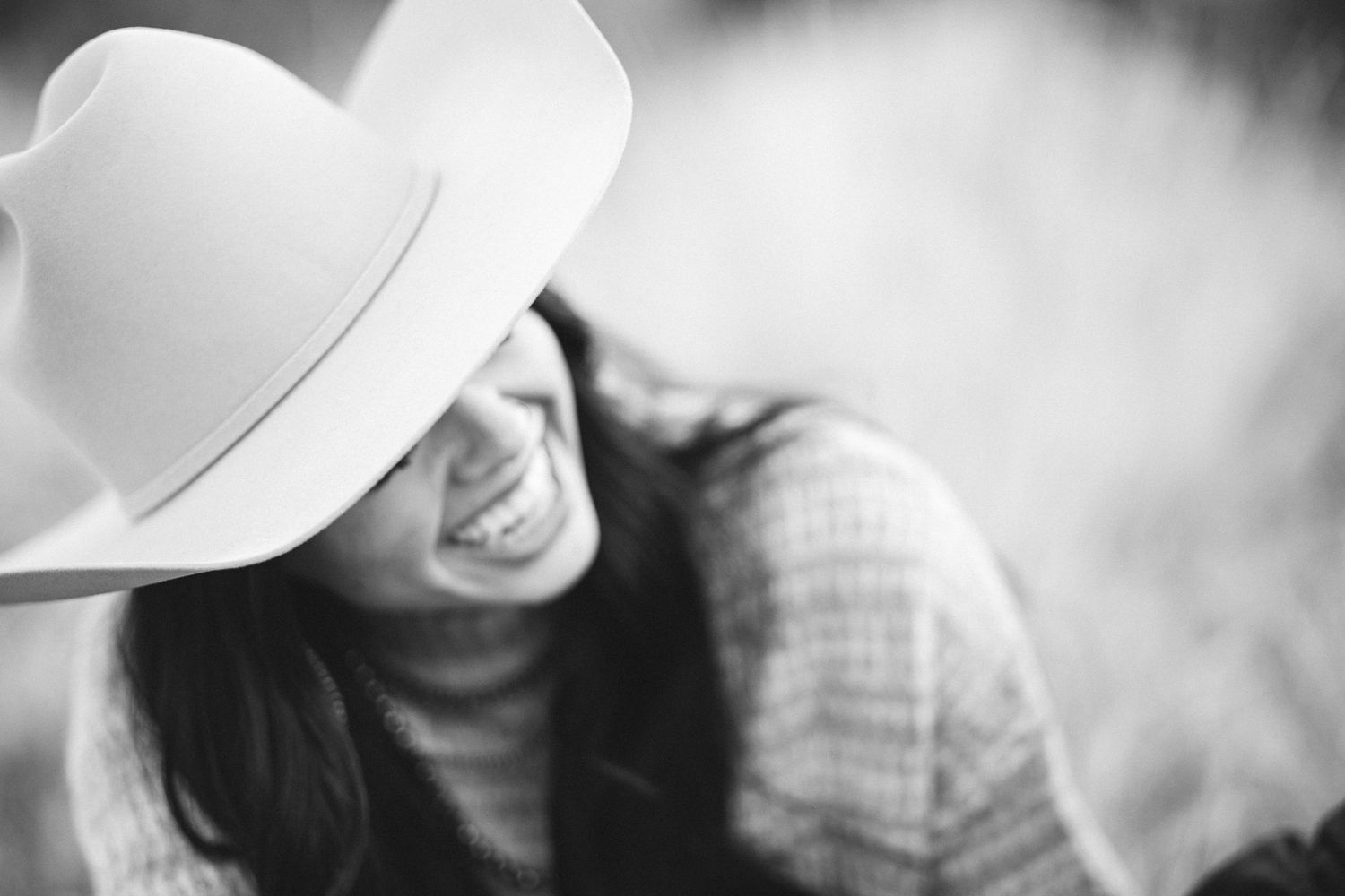 an unclose photo shows a young girl smiling in her cowboy hat in a black and white photo after her engagement in the boise foothills
