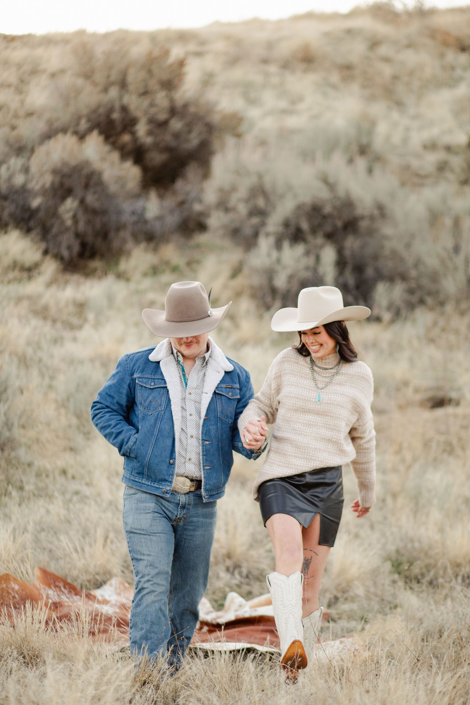 Young couple poses as they get their engagement photos taken in the boise Idaho foot hills taken by Stoked Media photography