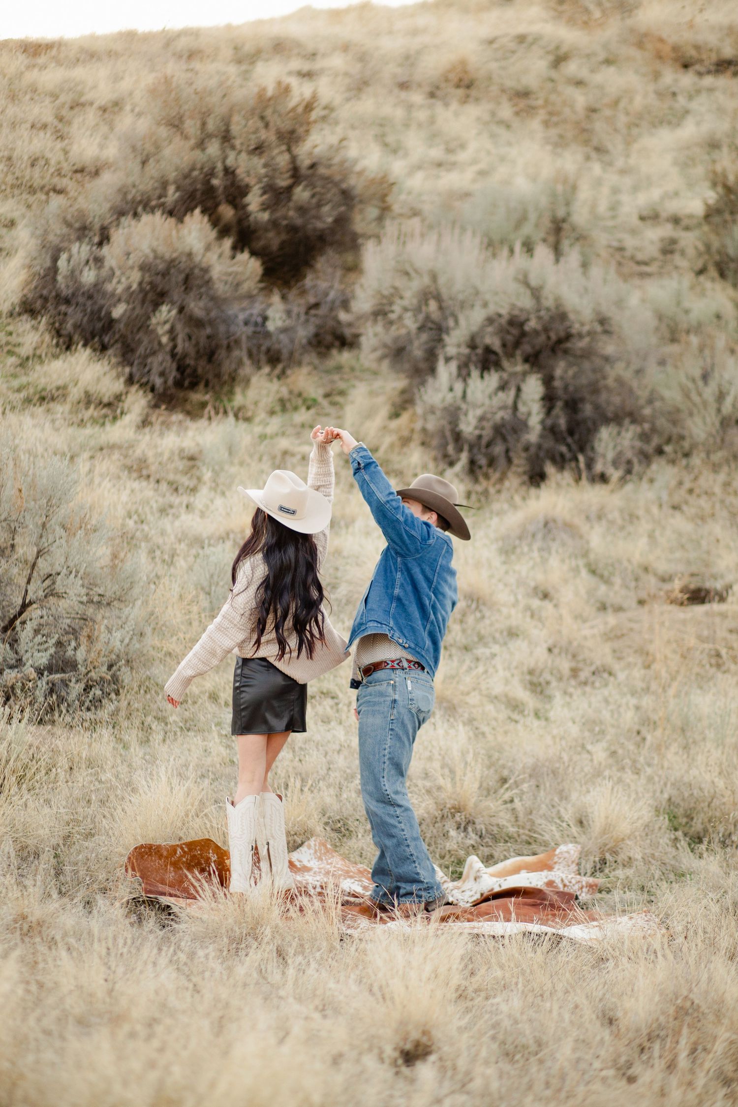 Just engaged couple celebrate by dancing in the boise foot hills just after the sun went down